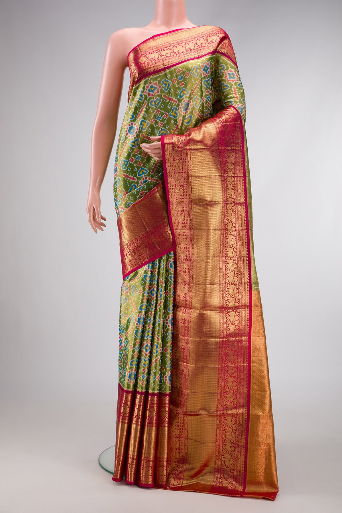 Pure Silk Pure Zari Mehandi Green Dual Tone Kanjivaram Tissue Saree with Ikat Print on the body and Zari Border.  displayed on a mannequin