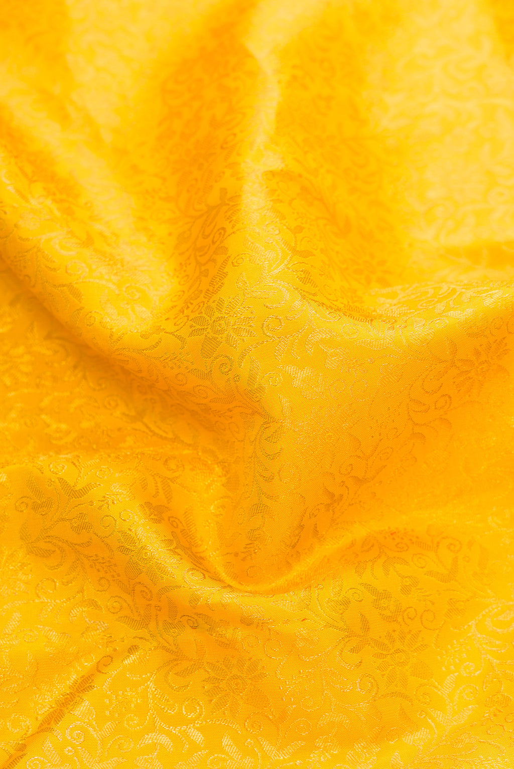 Close up of Yellow Dual Tone Kanchipuram Silk Saree with Zari Brocade on the body and Zari Border.  displaying folds