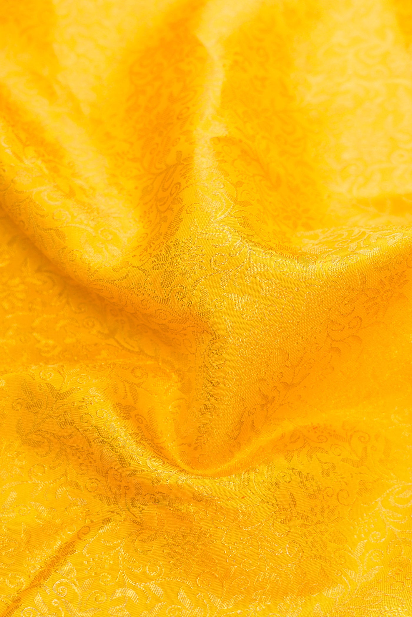 Close up of Yellow Dual Tone Kanchipuram Silk Saree with Zari Brocade on the body and Zari Border.  displaying folds
