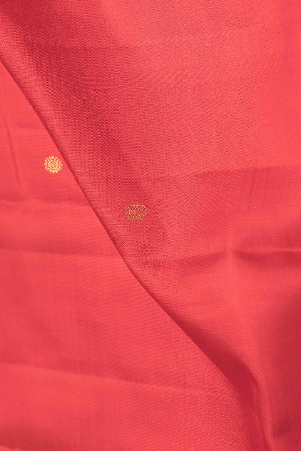 Close up of Red Dual Tone Kanchipuram Saree with Zari Butta on the body and Plain Border.  displaying folds
