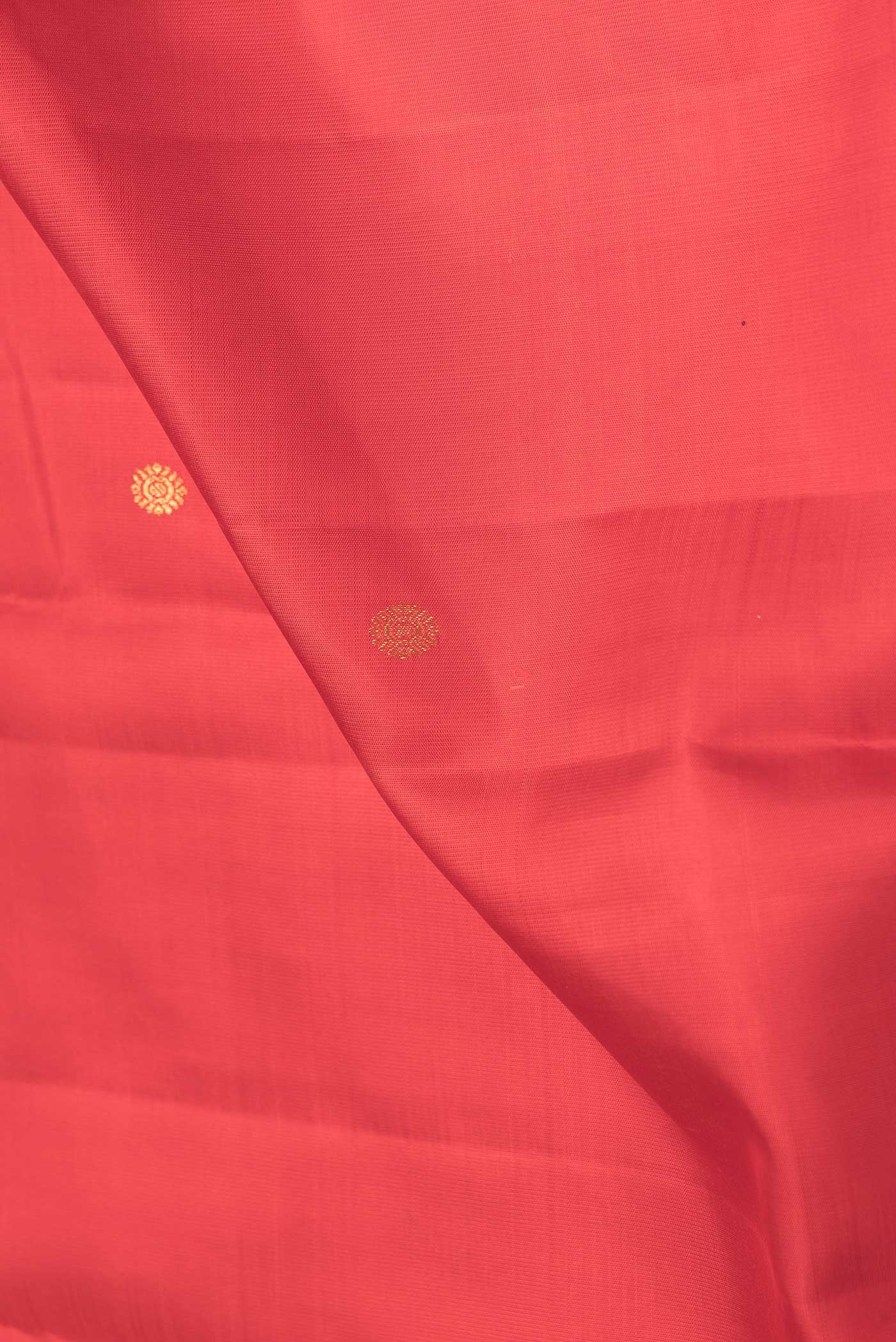 Close up of Red Dual Tone Kanchipuram Saree with Zari Butta on the body and Plain Border.  displaying folds