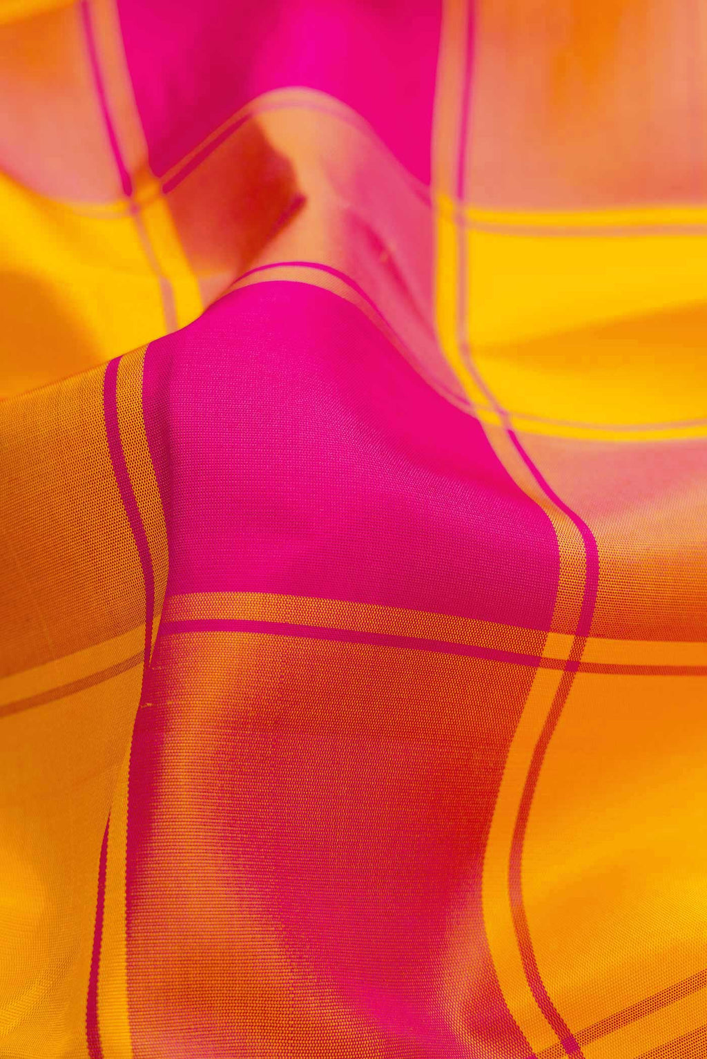 Close up of Pure Silk Pure Zari Yellow and Pink Color Kanchipuram Saree with Checked design on the body and Zari Border displaying folds