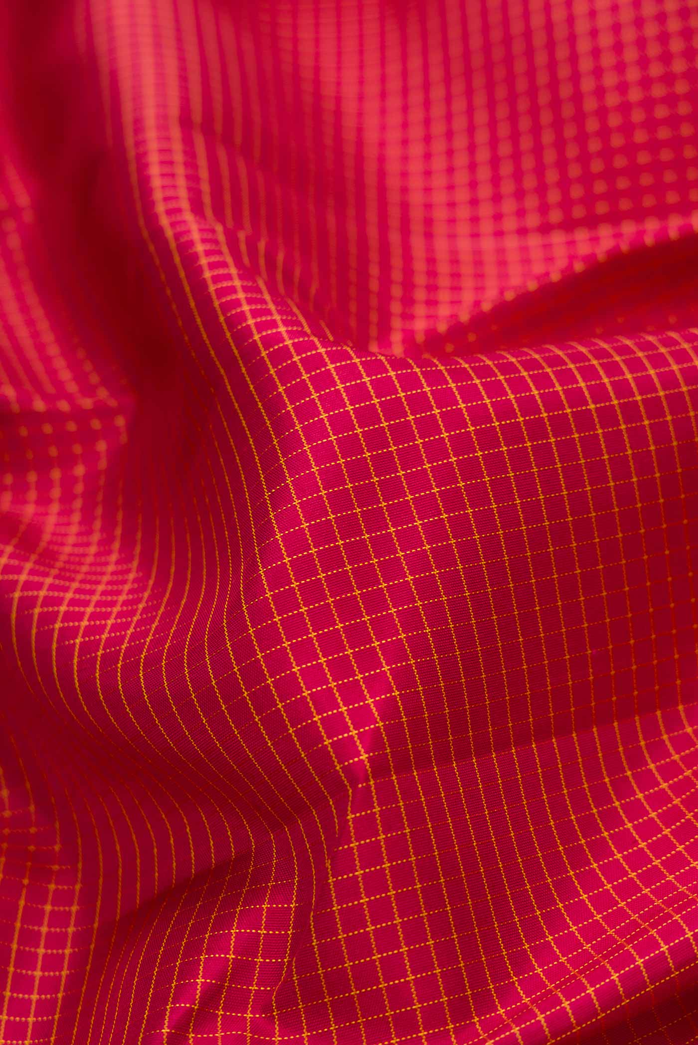 Close up of Maroon Dual Tone Kanchipuram Silk Saree with Checked design on the body and Zari Border displaying folds