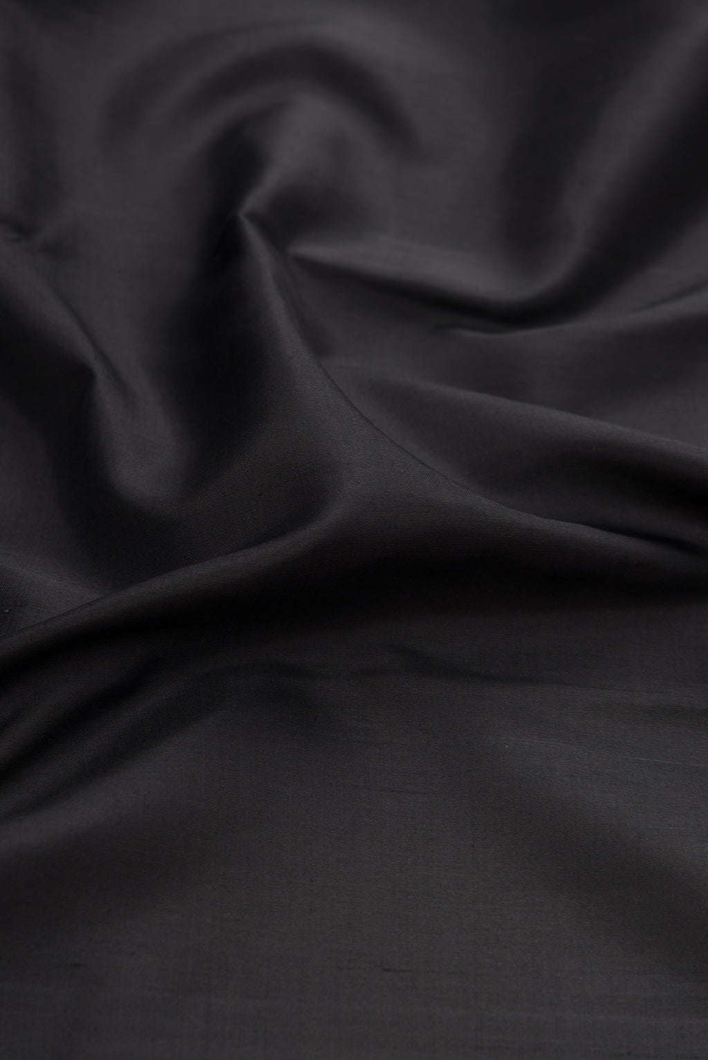 Close up of Black Kanjivaram Silk Saree with Plain Body and Zari Border.  displaying folds
