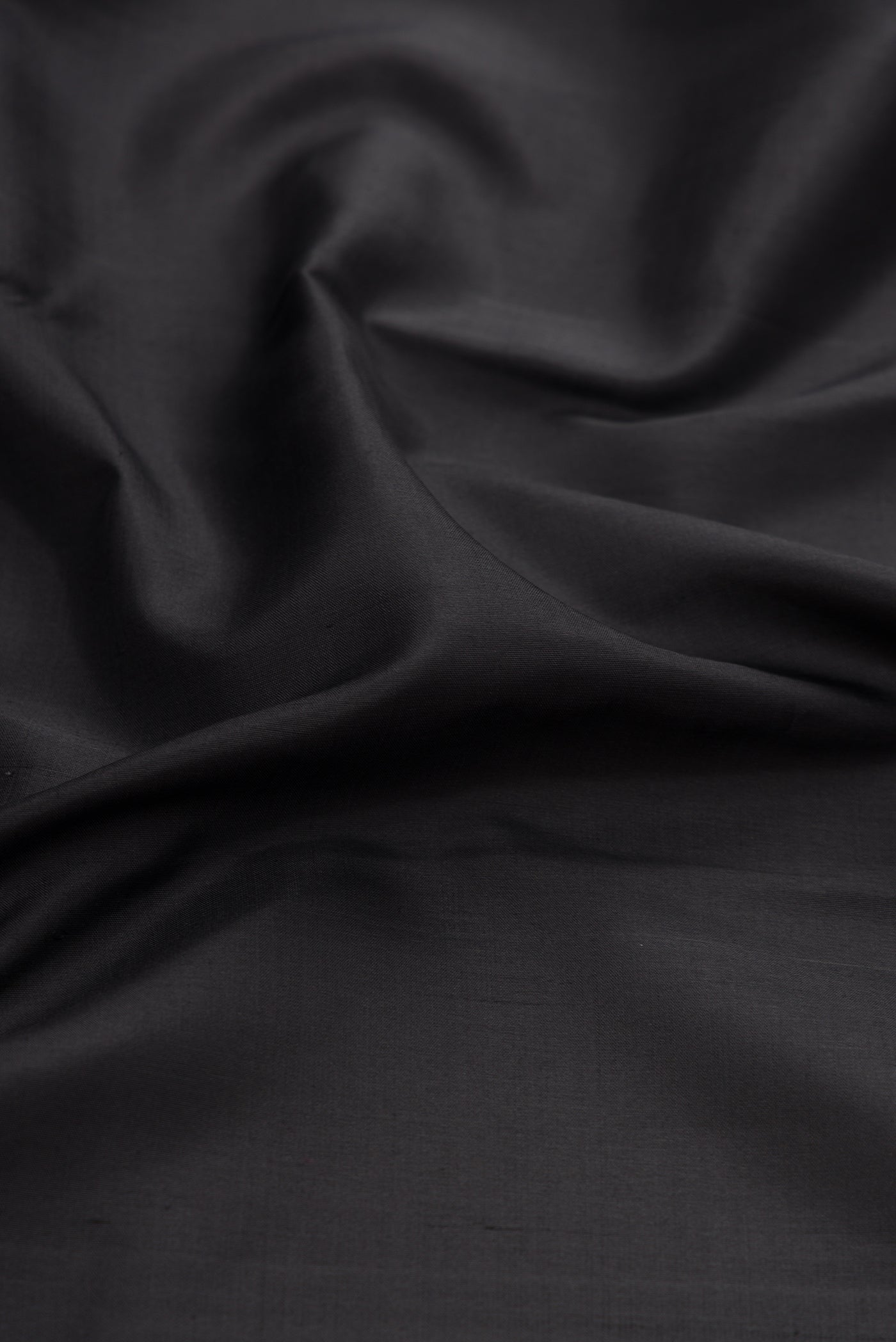 Close up of Black Kanjivaram Silk Saree with Plain Body and Zari Border.  displaying folds
