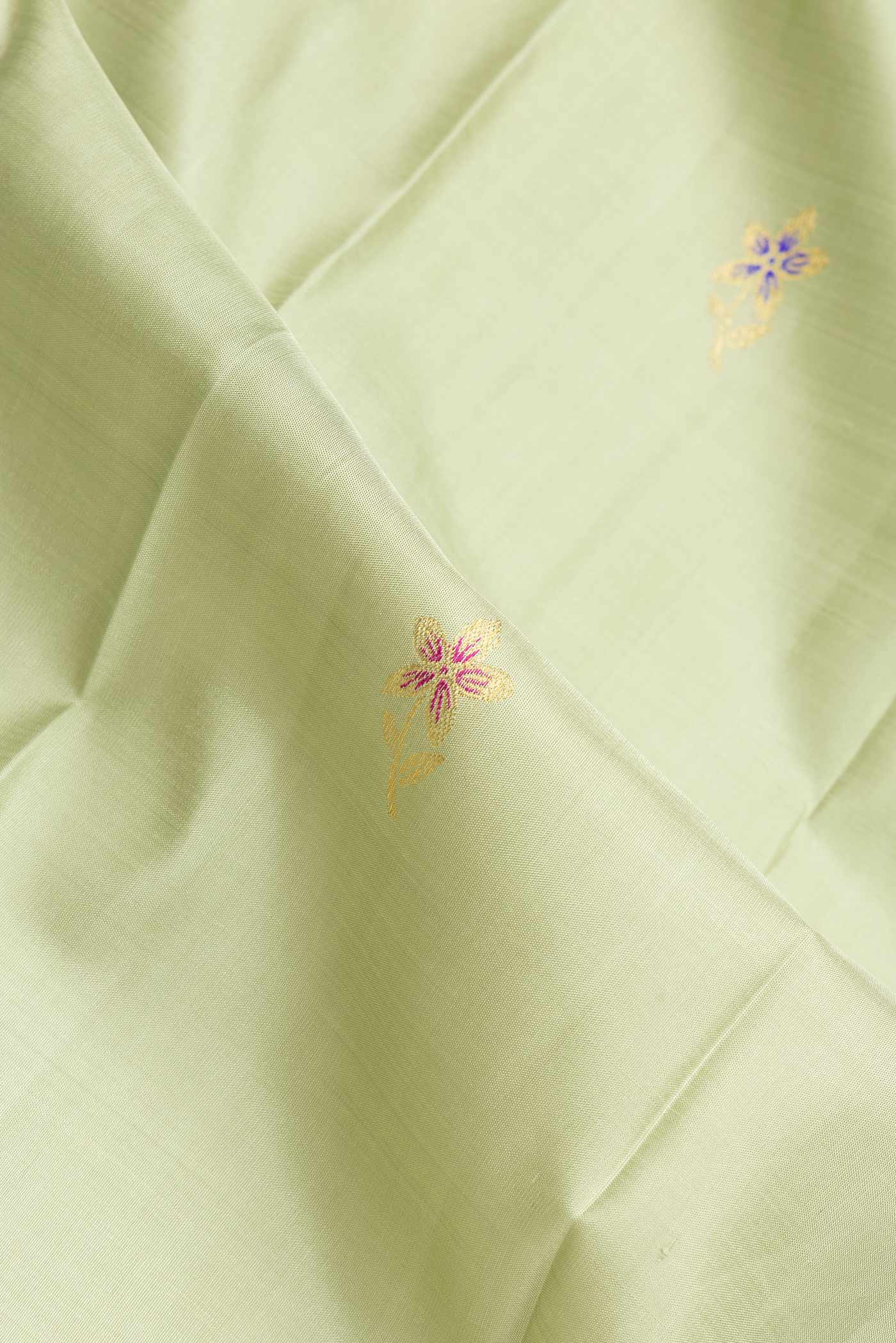 Close up of Pista Green Dual Tone Kanchipuram Silk Saree with Zari And Thread Butta on the body and Zari Border.  displaying folds