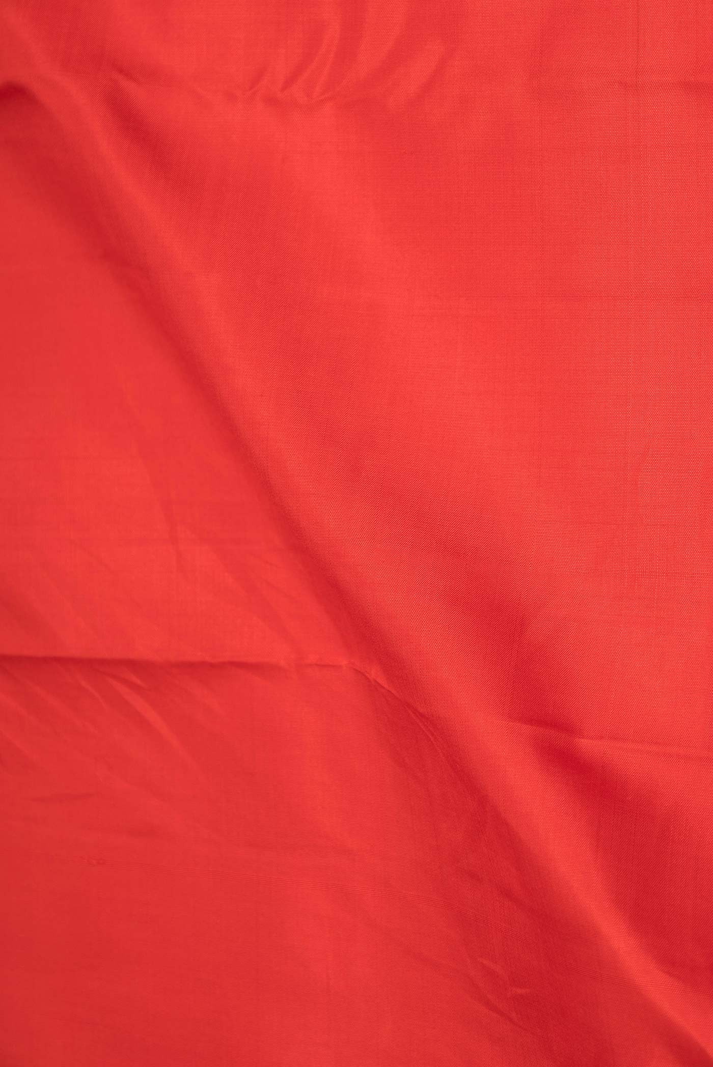 Close up of Red Dual Tone Kanchipuram Silk Saree with Plain Body and Zari Border displaying folds