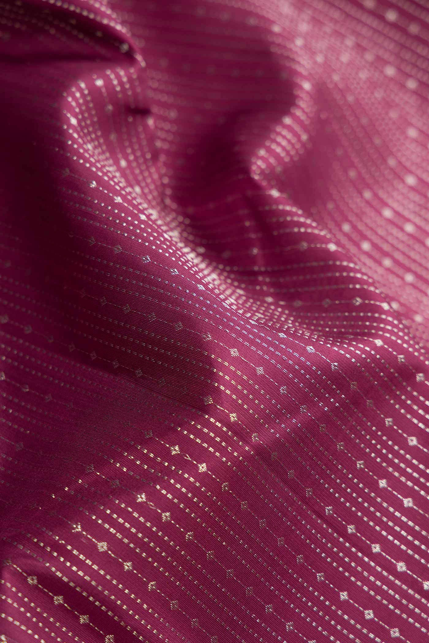 Close up of Maroon Dual Tone Kanchipuram Silk Saree with Stripes on the body and Zari Border displaying folds