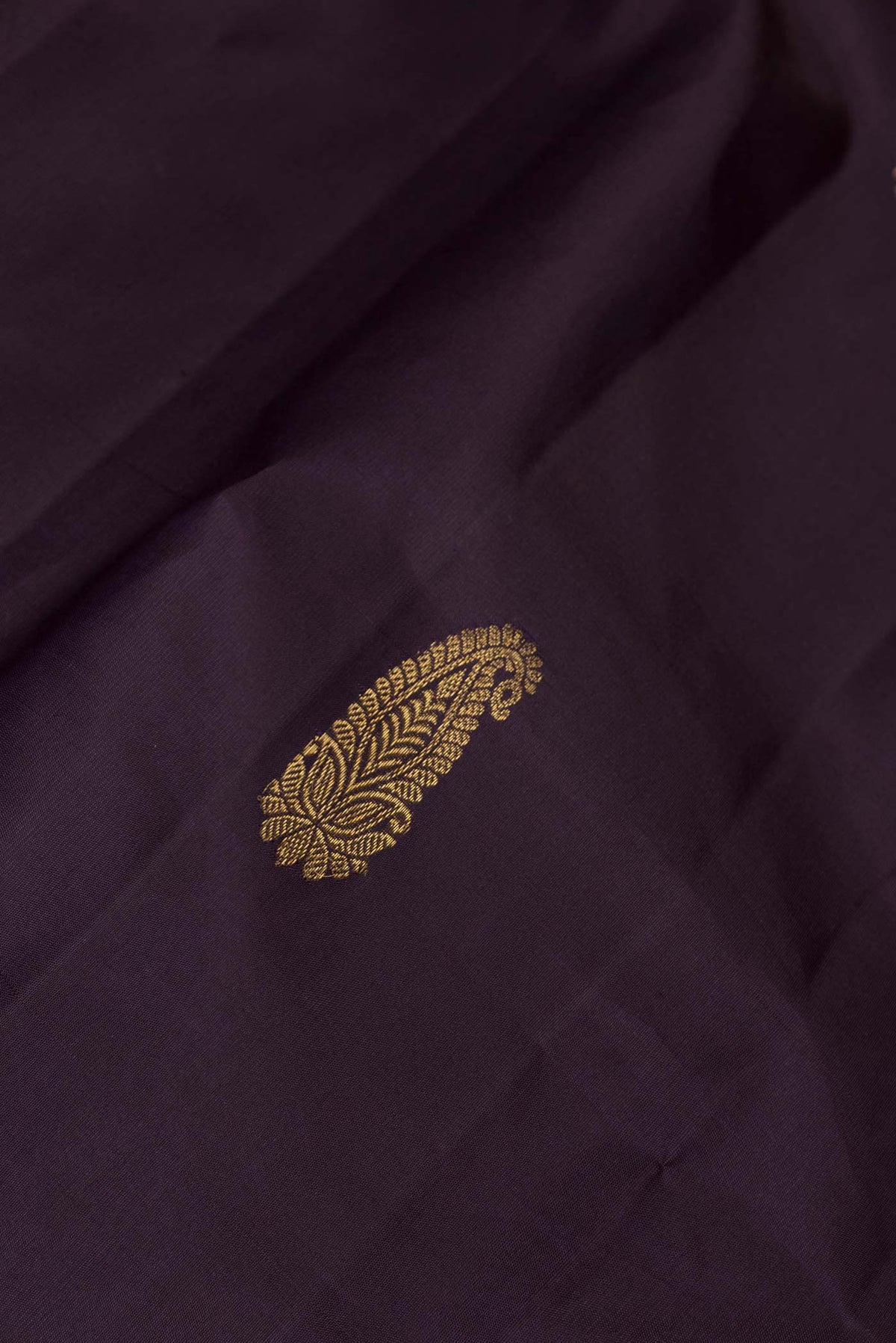 Close up of Burgundy Dual Tone Kanchipuram Silk Saree with Zari Butta on the body and Zari Border displaying folds