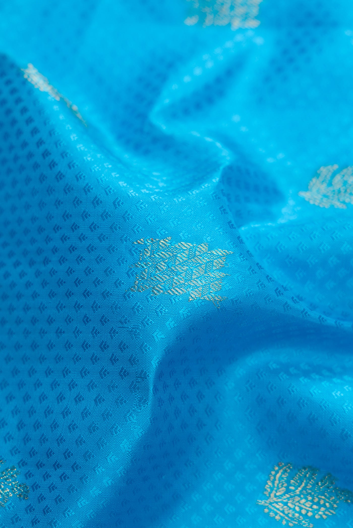 Close up of Pure Silk Pure Zari Sky Blue Dual Tone Kanchipuram Saree with Jacquard With Zari Butta on the body and Zari Border.  displaying folds