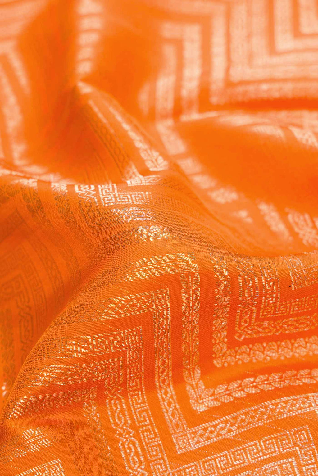 Close up of Orange Dual Tone Kanchipuram Silk Saree with Zari Brocade on the body and Zari Border.  displaying folds