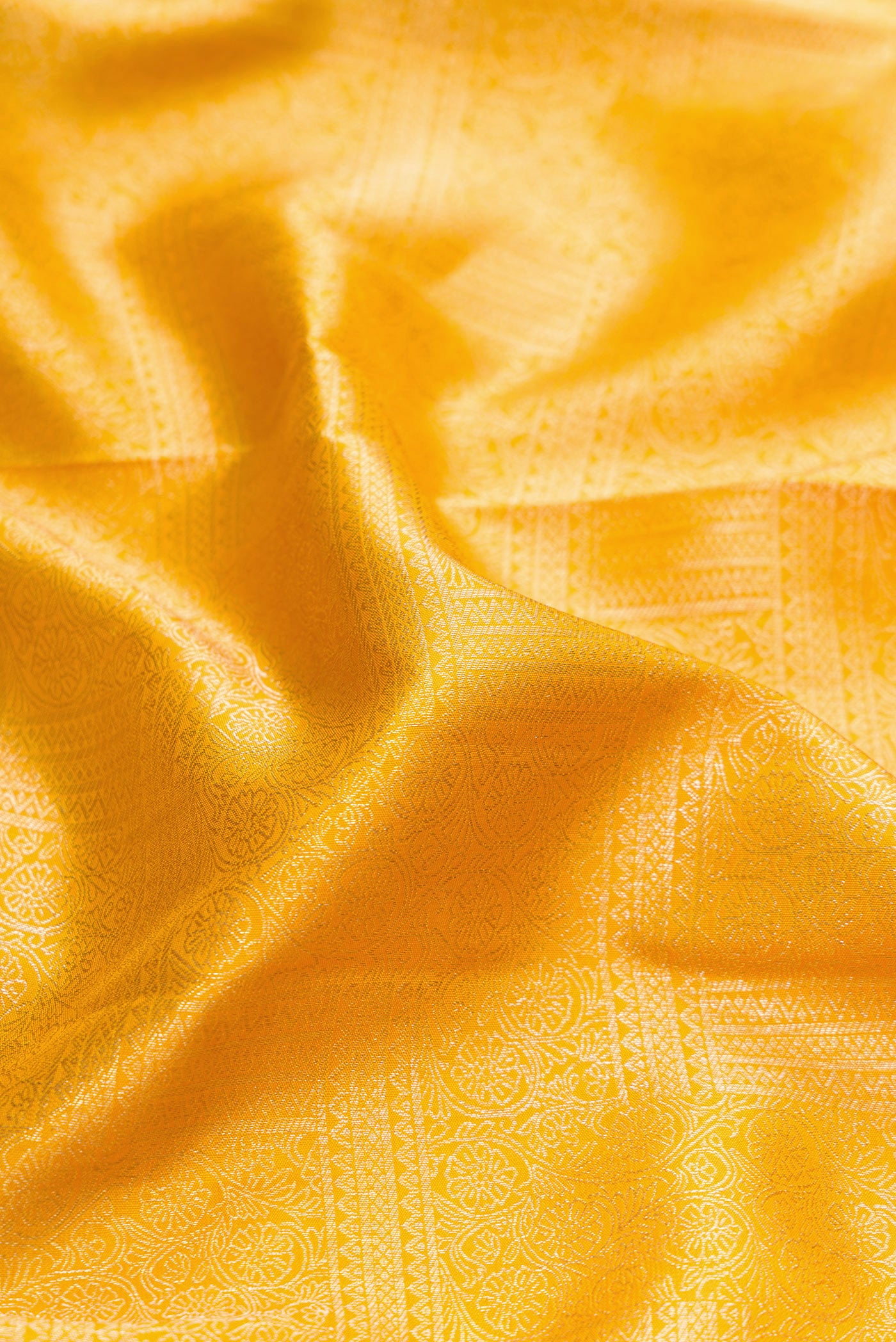 Close up of Mustard Dual Tone Kanjivaram Silk Saree with Zari Brocade on the body and Zari Border.  displaying folds