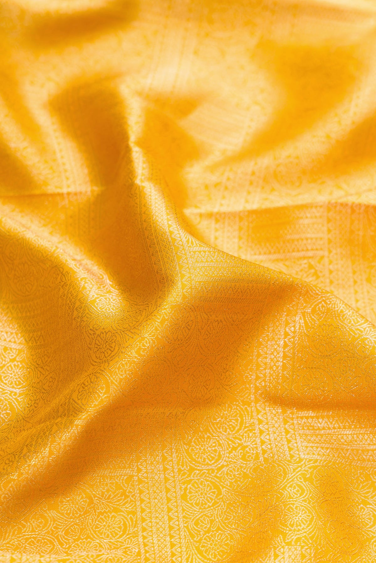 Close up of Mustard Dual Tone Kanjivaram Silk Saree with Zari Brocade on the body and Zari Border.  displaying folds