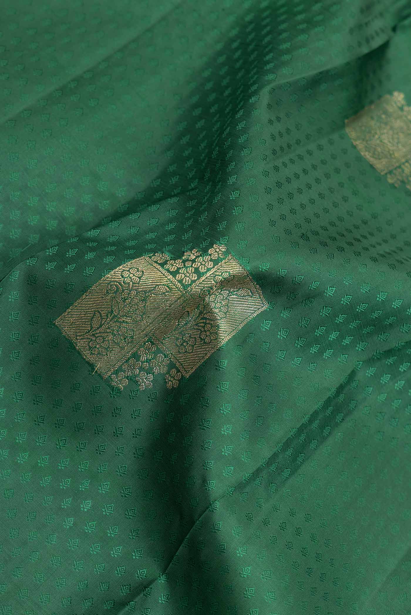 Close up of Green Dual Tone Kanchipuram Saree with Jacquard With Zari Butta on the body and Zari Border displaying folds