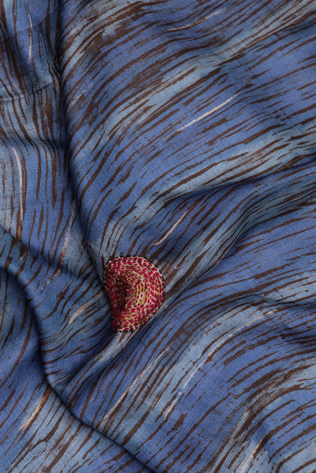 Close up of Blue Tussar Silk Saree with Embroidery on the body and Embroidery Border.  displaying folds