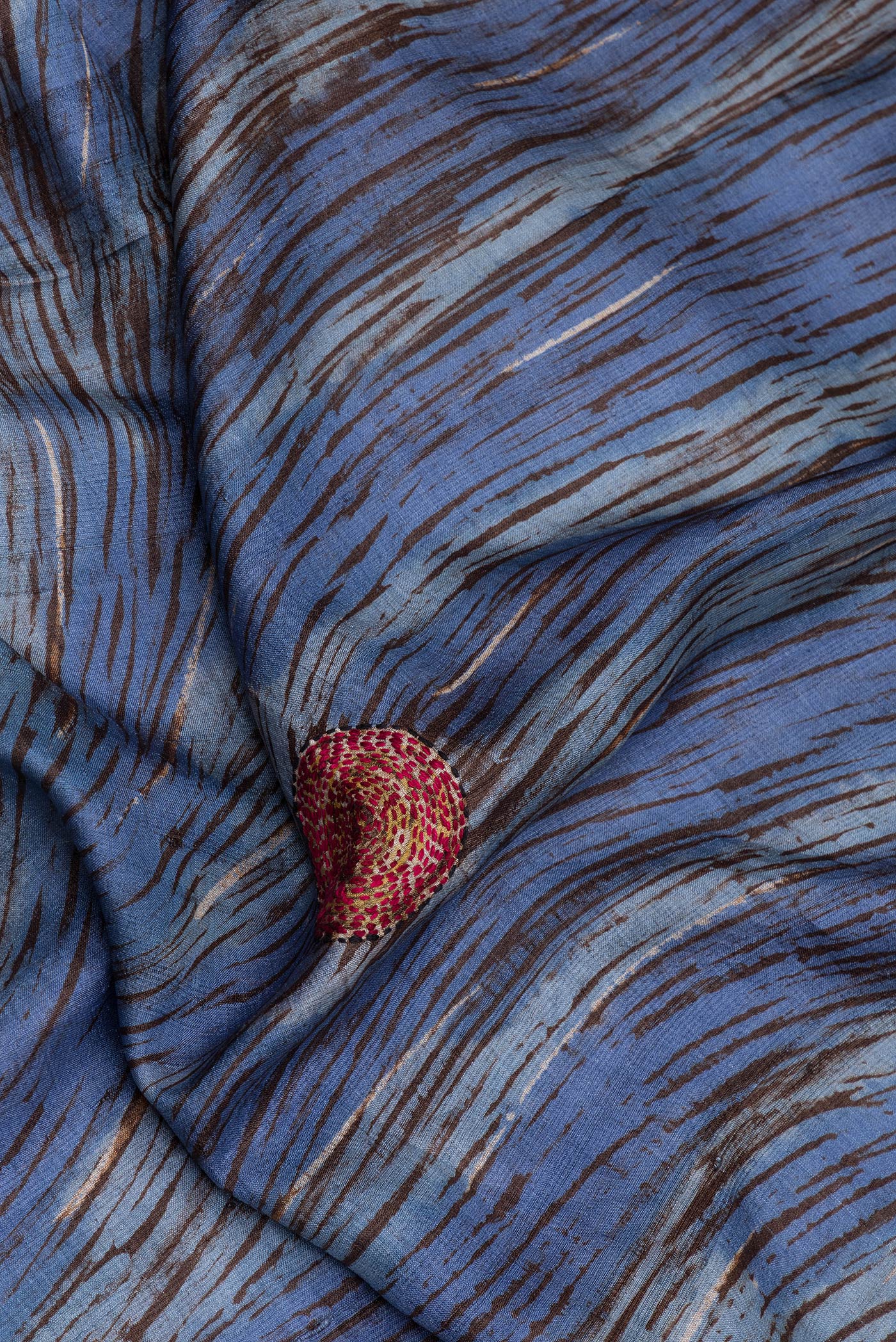 Close up of Blue Tussar Silk Saree with Embroidery on the body and Embroidery Border.  displaying folds