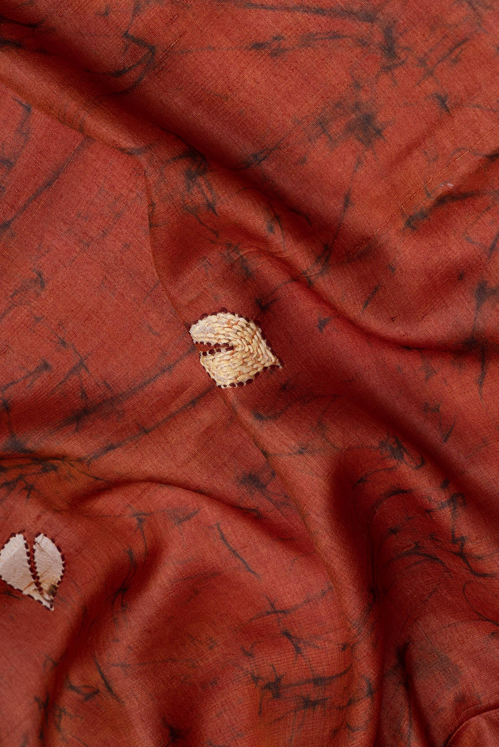Close up of Brick Orange Tussar Silk Saree with Embroidery on the body and Embroidery Border.  displaying folds