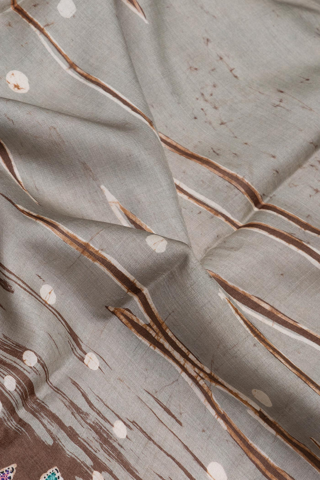 Close up of Grey Tussar Silk Saree with Embroidery on the body and Embroidery Border.  displaying folds