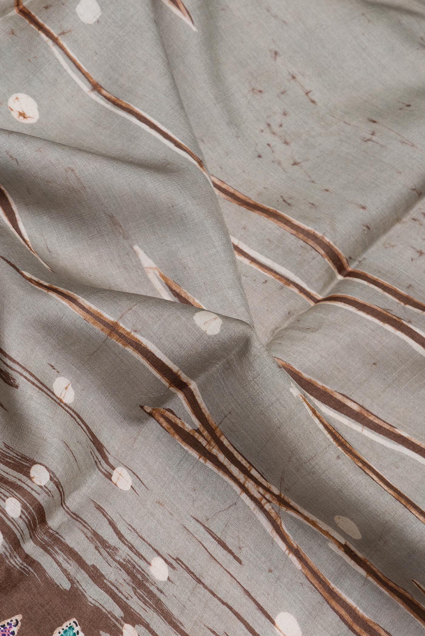 Close up of Grey Tussar Silk Saree with Embroidery on the body and Embroidery Border.  displaying folds