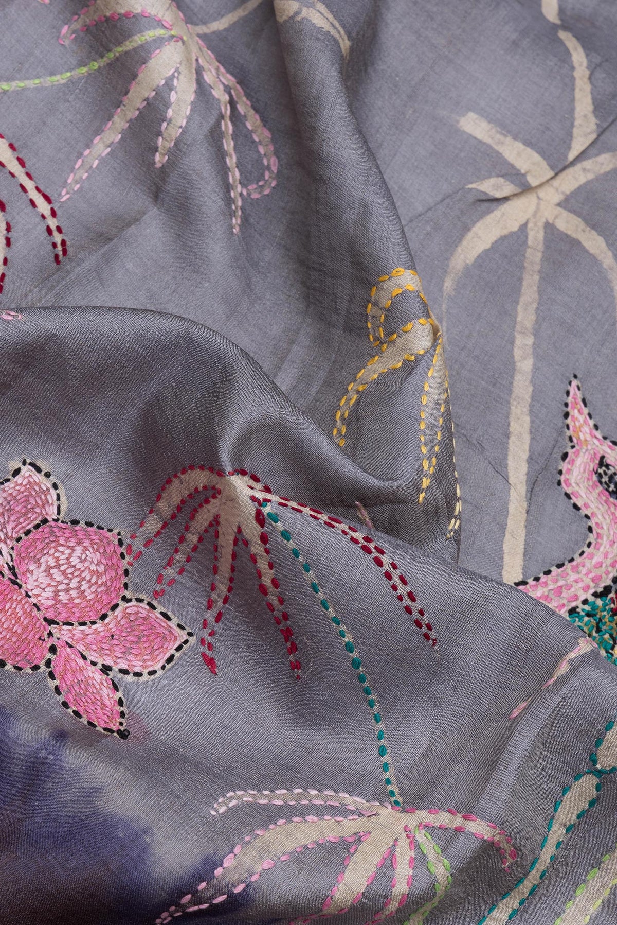 Close up of Grey Tussar Silk Saree with Embroidery on the body and Embroidery Border.  displaying folds