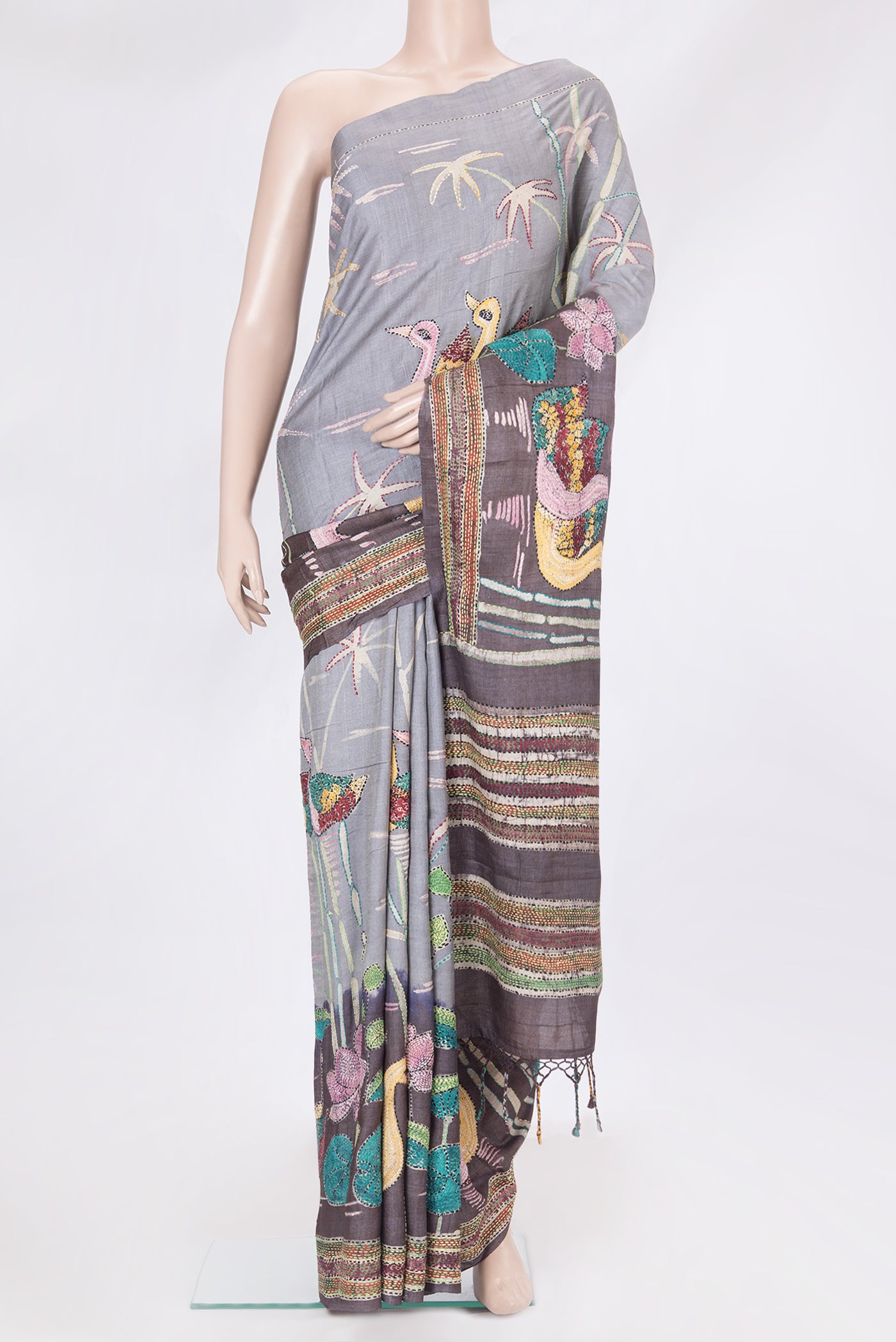 Grey Tussar Silk Saree with Embroidery on the body and Embroidery Border.  displayed on a mannequin