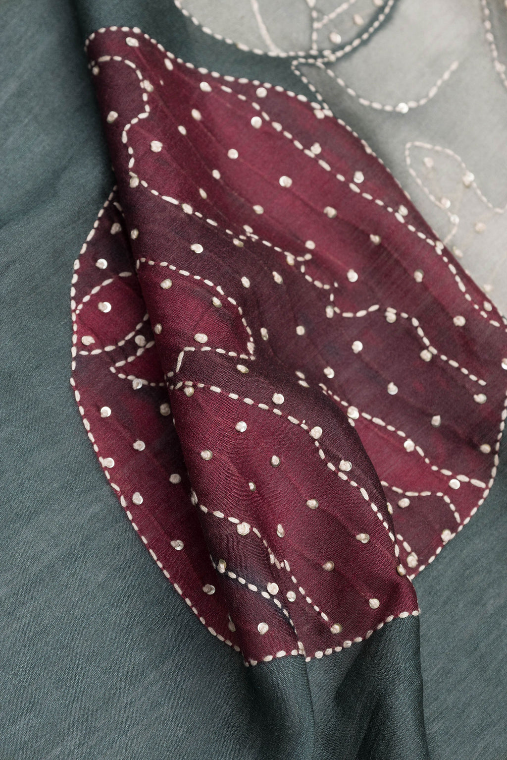 Close up of Grey Tussar Silk Saree with Embroidery on the body and Embroidery Border.  displaying folds