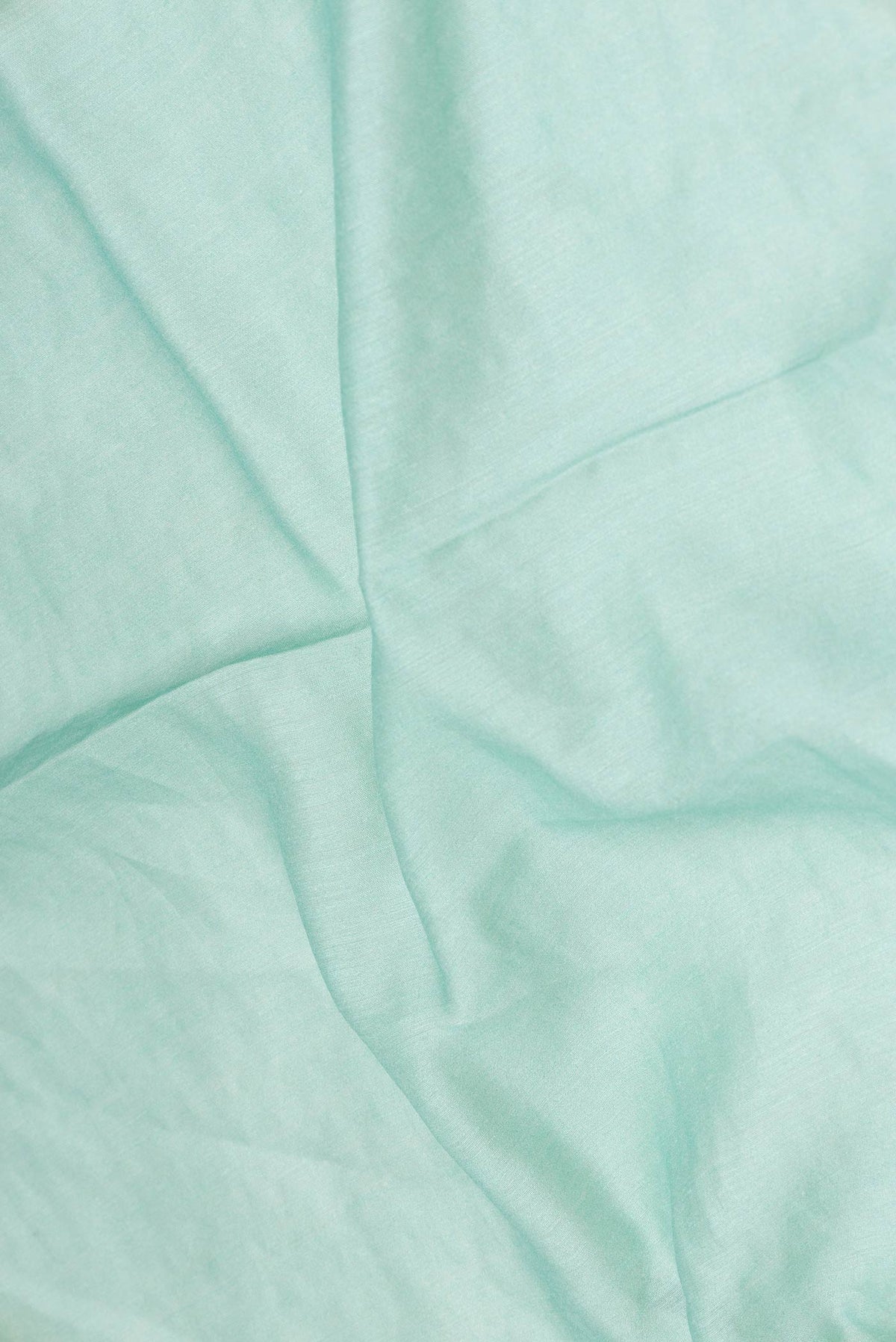 Close up of Light Blue Dual Tone Tussar Silk Saree with Embroidery on the body and Zari And Thread Border displaying folds