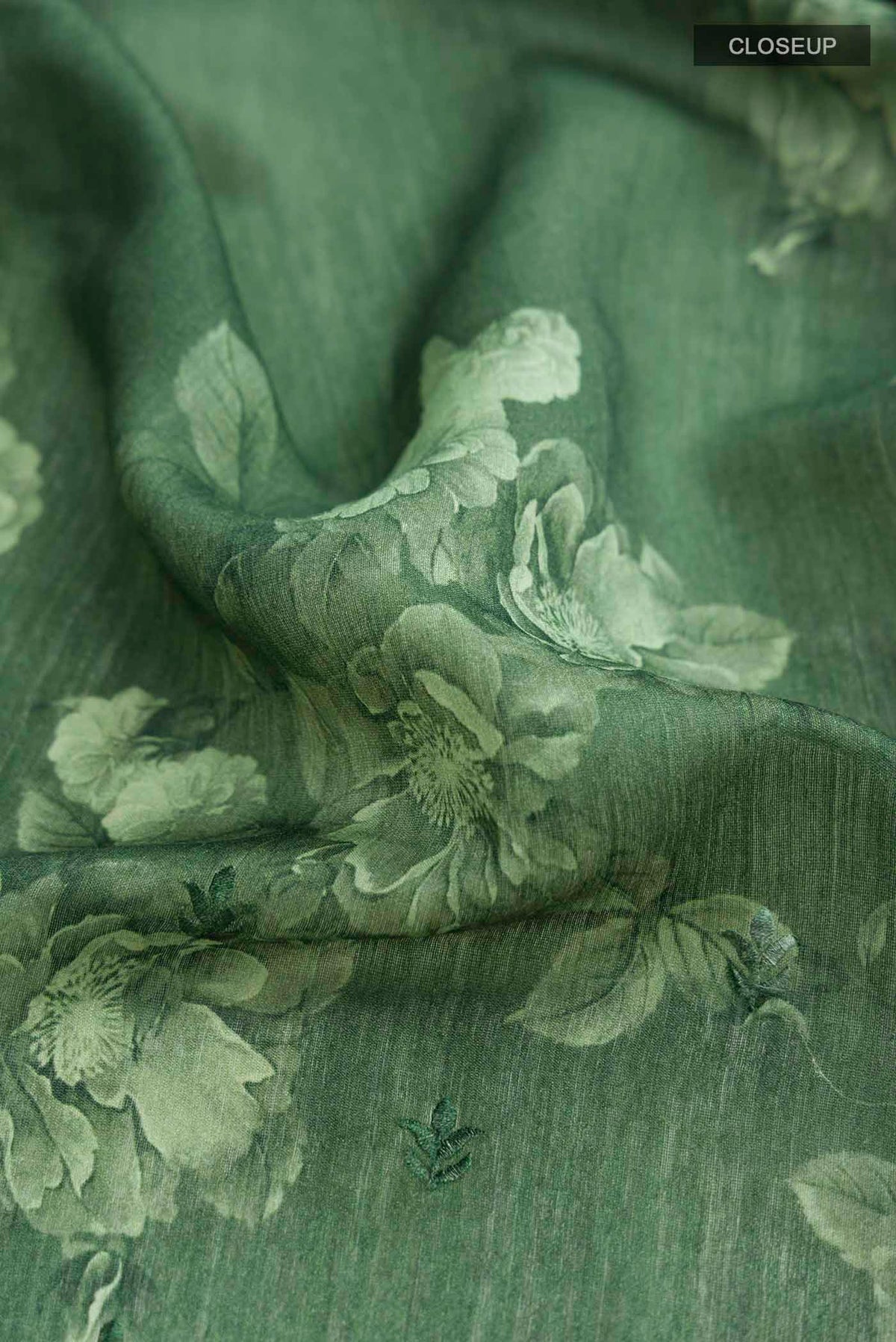 Close up of Green Tussar Silk Saree with Thread Butta on the body and Zari Border displaying folds