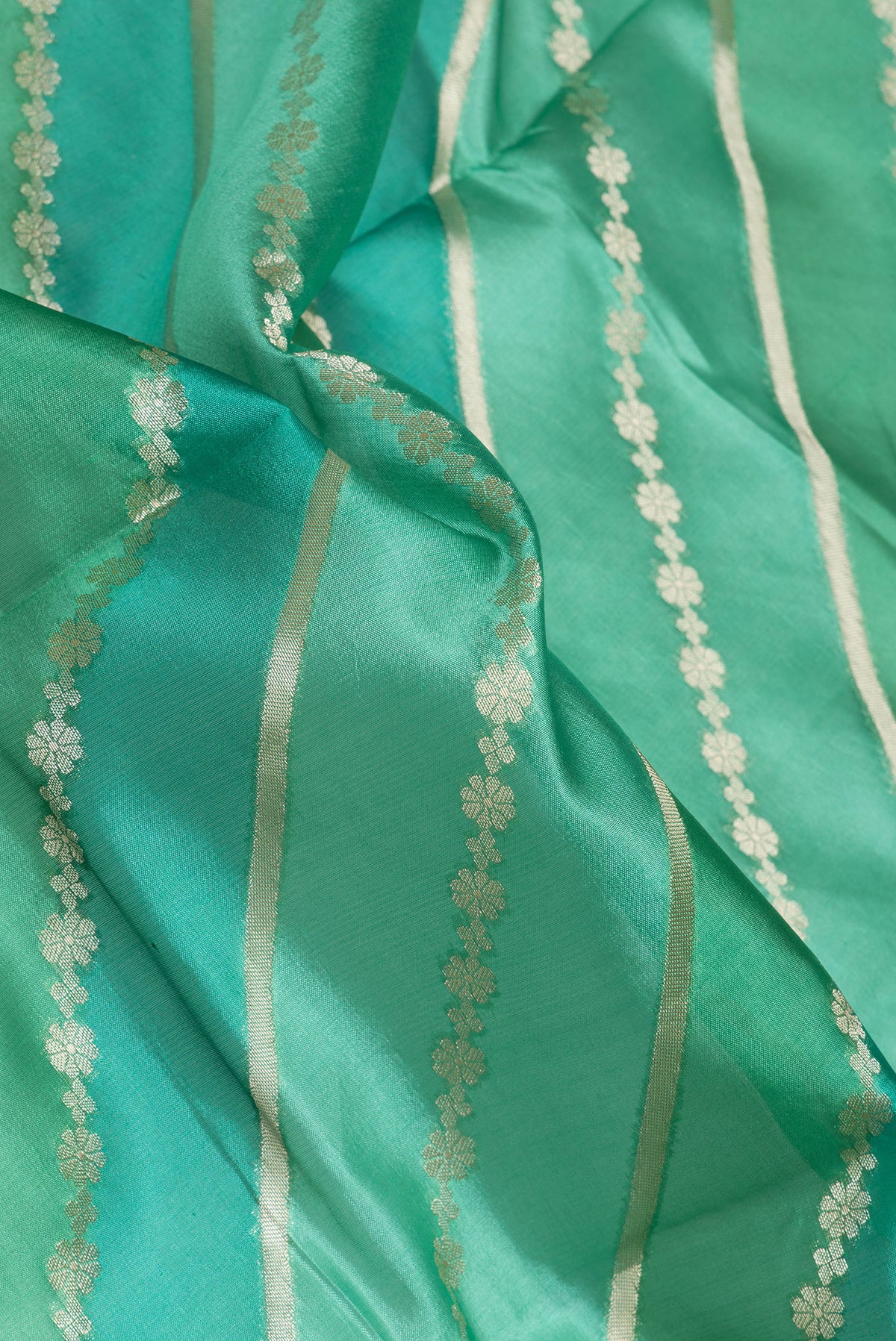 Close up of Green Tussar Silk Saree with Zari Brocade on the body and Zari Border.  displaying folds