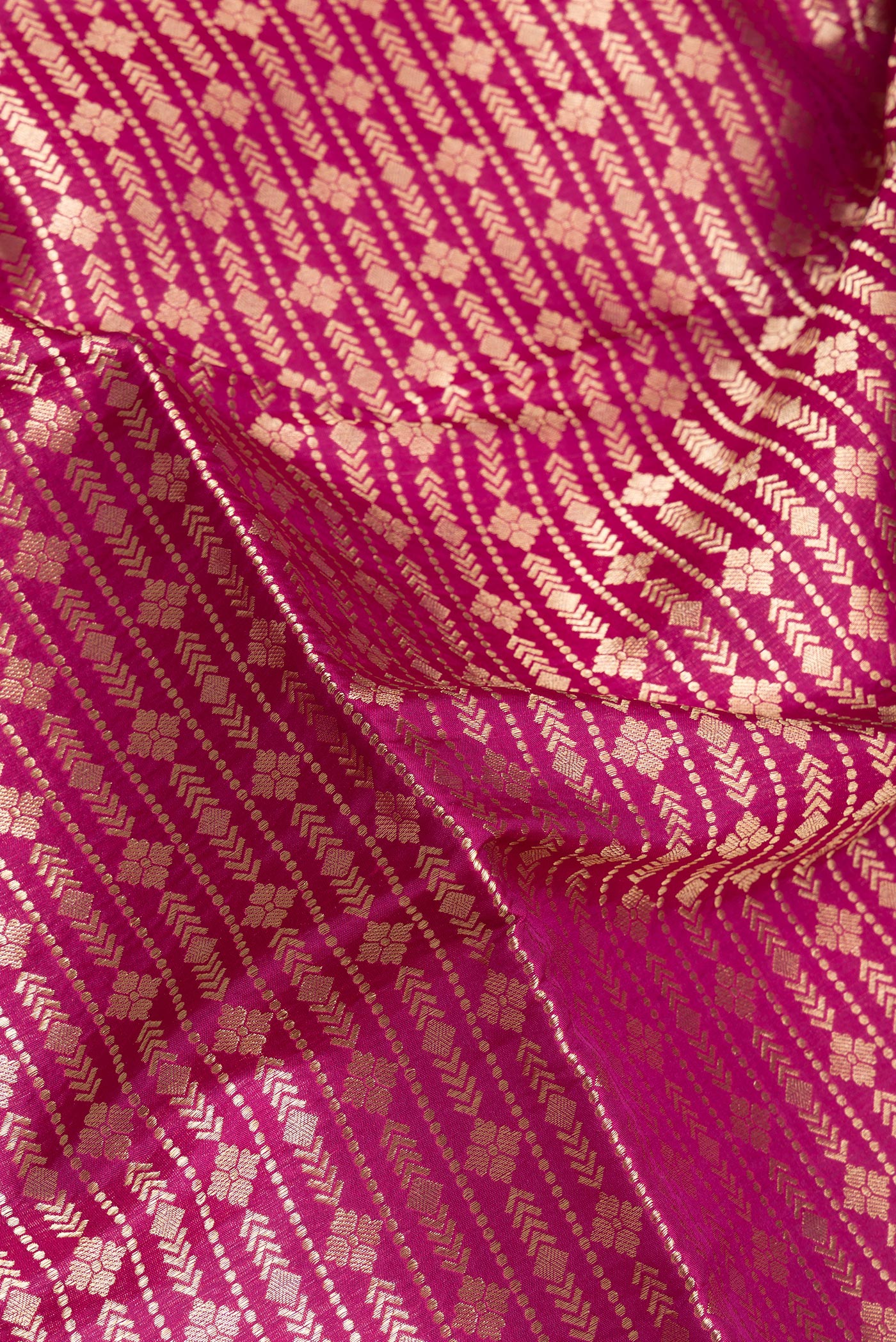 Close up of Magenta Banarasi Silk Saree with Zari Brocade on the body and Zari Border.  displaying folds
