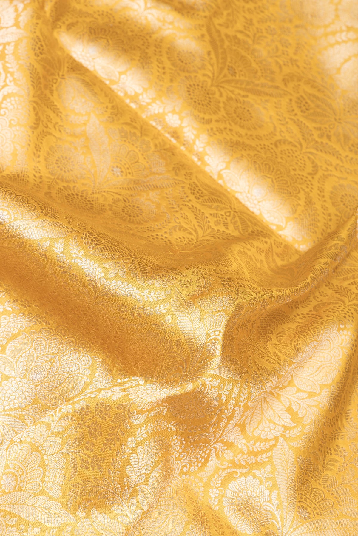 Close up of Yellow Dual Tone Banarasi Silk Saree with Zari Brocade on the body and Zari Border.  displaying folds
