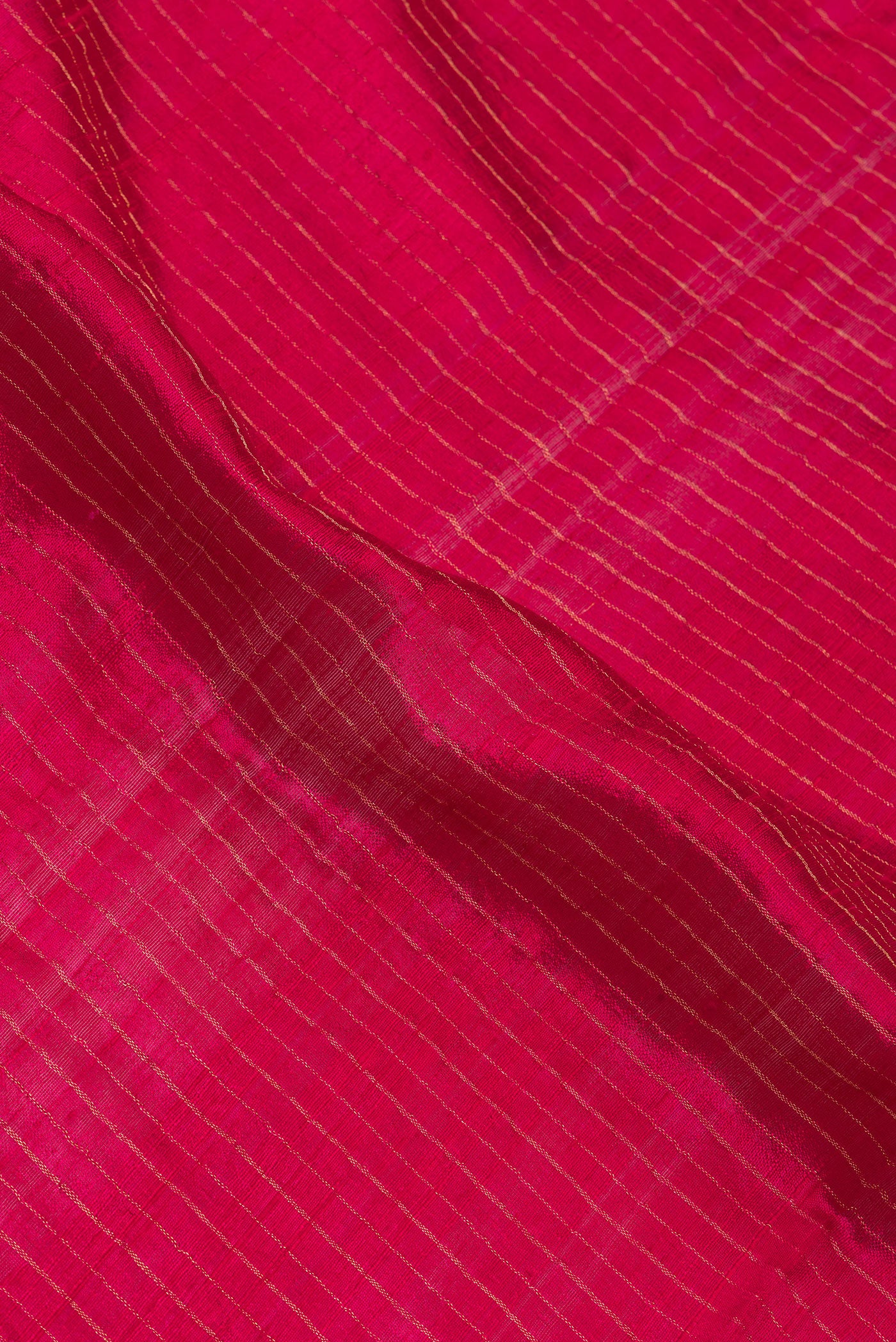 Close up of Dark Pink Tussar Silk Saree with Stripes on the body and Fancy Border.  displaying folds