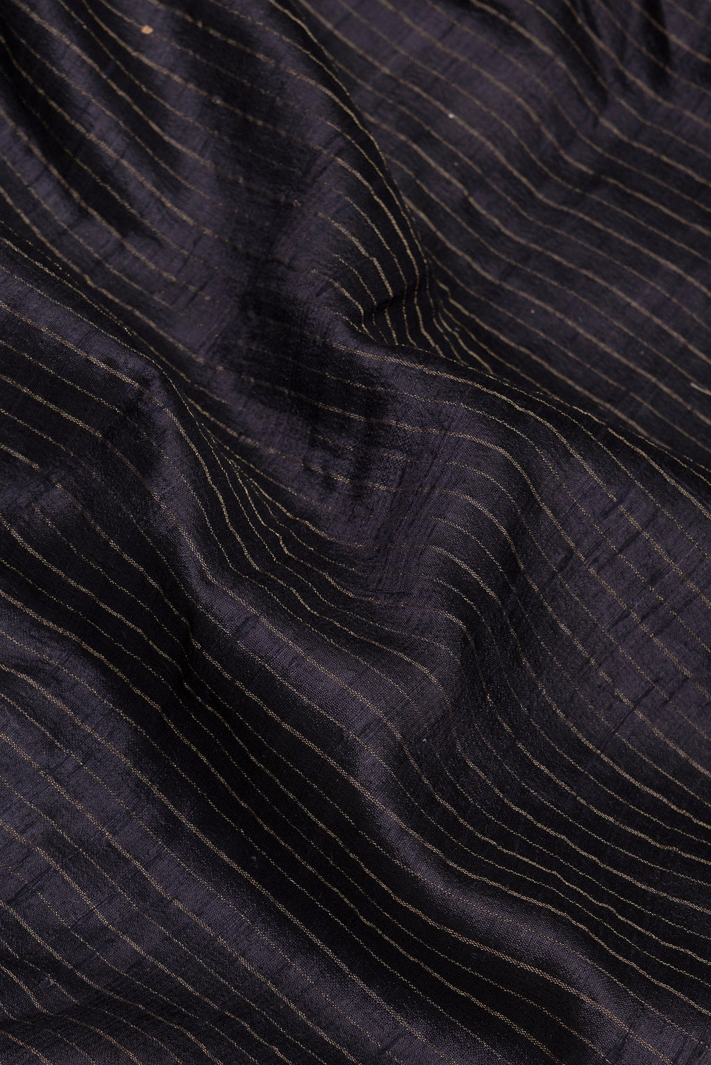 Close up of Black Tussar Silk Saree with Stripes on the body and Embroidery Border.  displaying folds