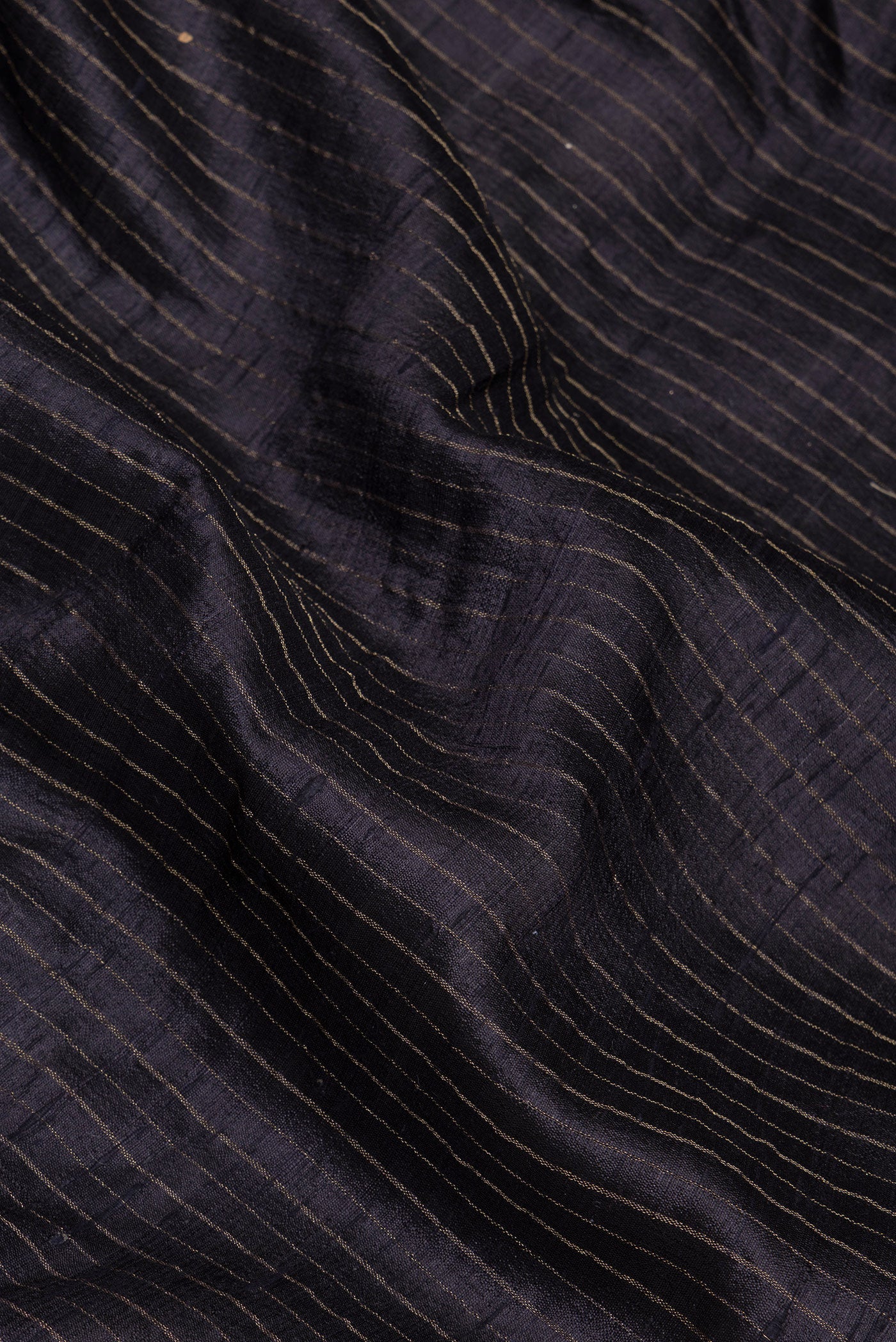 Close up of Black Tussar Silk Saree with Stripes on the body and Embroidery Border.  displaying folds