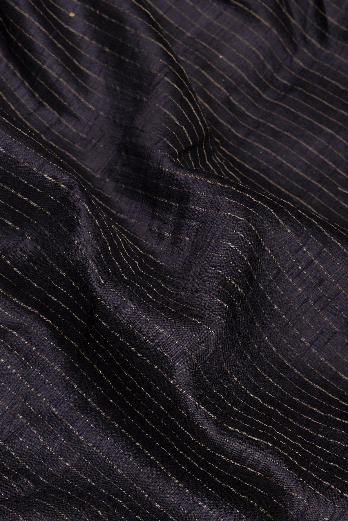 Close up of Black Tussar Silk Saree with Stripes on the body and Embroidery Border.  displaying folds