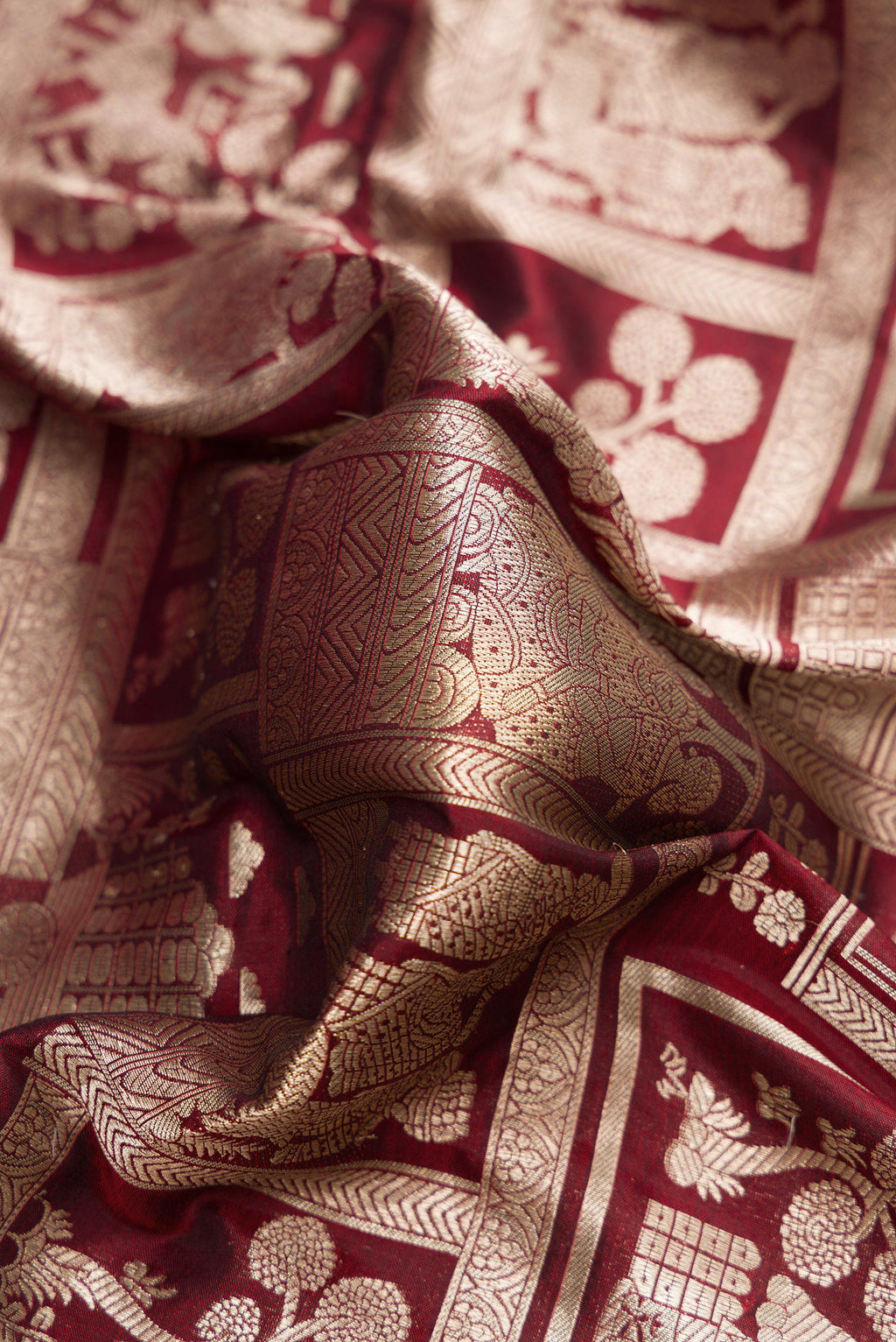 Close up of Maroon Dual Tone Banarasi Silk Saree with Zari Brocade on the body and Zari Border.  displaying folds