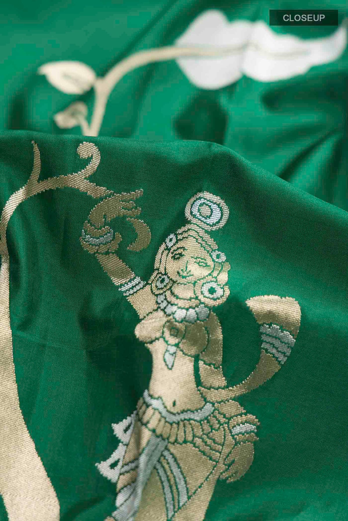 Close up of Green Banarasi Silk Saree with Zari Butta on the body and Zari Border displaying folds