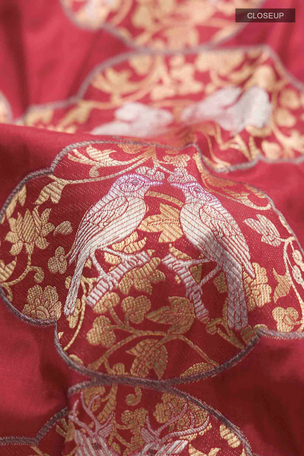 Close up of Maroon Banarasi Silk Saree with Zari Butta on the body and Zari Border displaying folds
