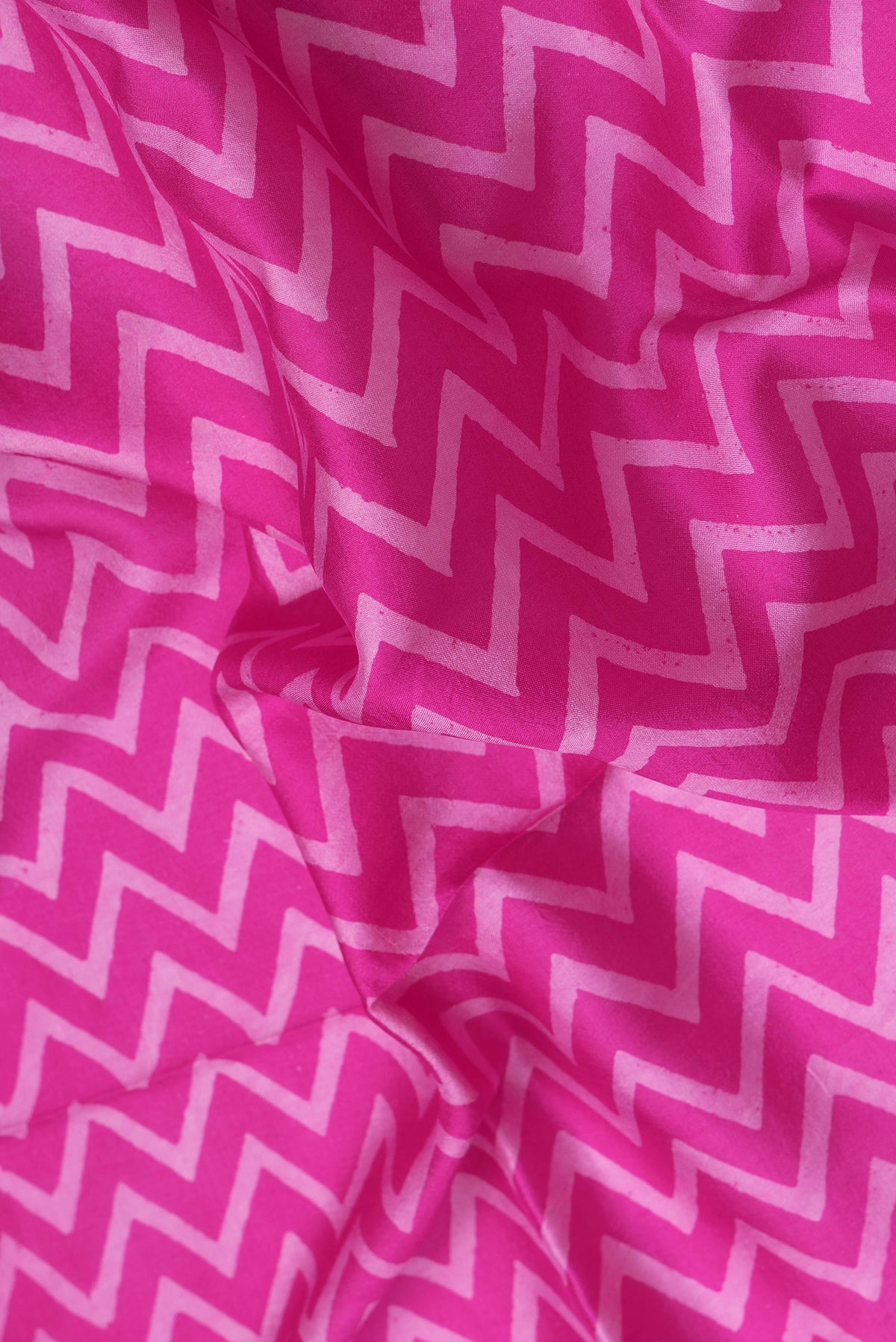 Close up of Pink Tussar Silk Saree with Printed design on the body and Zari Border.  displaying folds