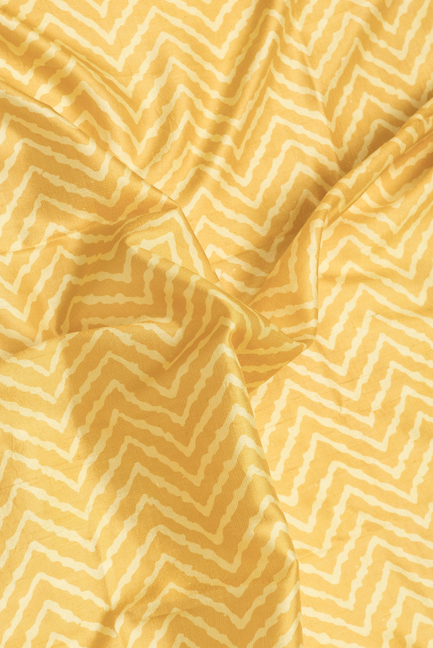 Close up of Yellow Dual Tone Tussar Silk Saree with Printed design on the body and Zari Border.  displaying folds