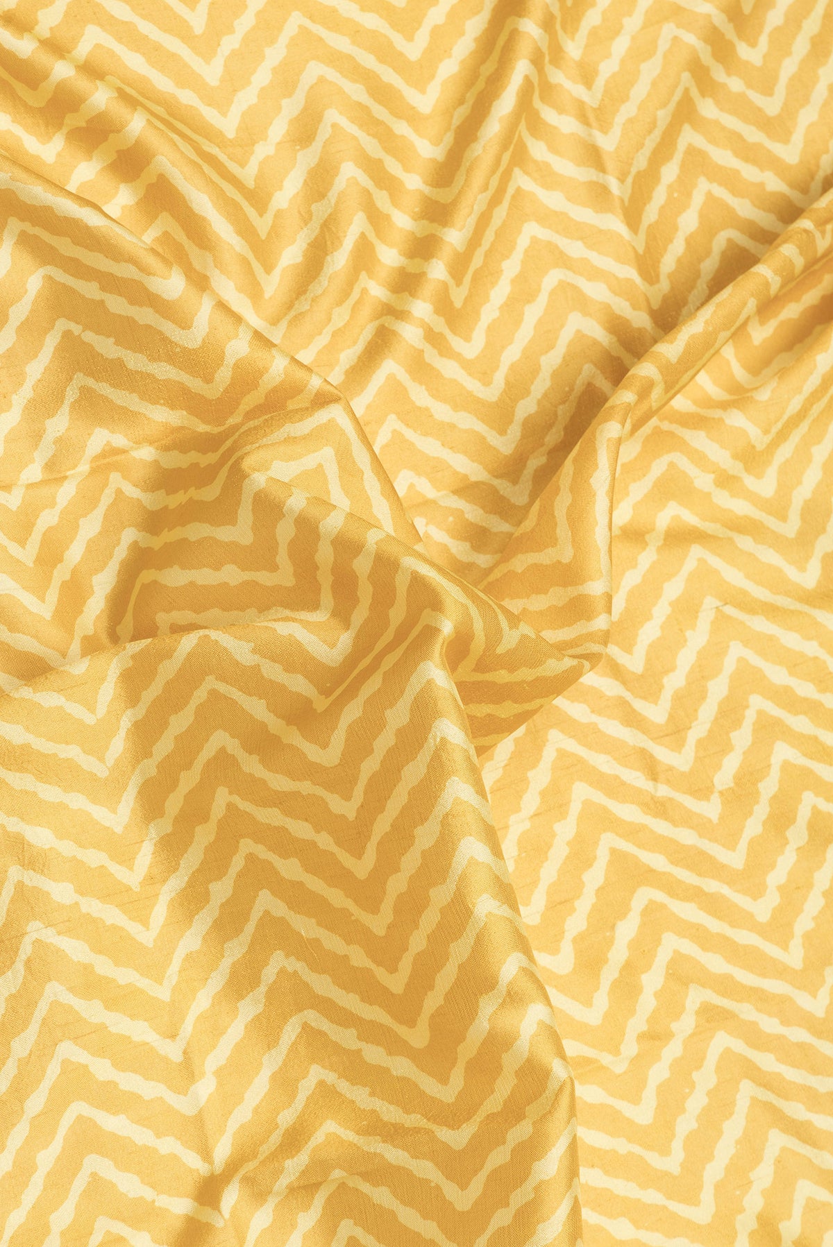 Close up of Yellow Dual Tone Tussar Silk Saree with Printed design on the body and Zari Border.  displaying folds