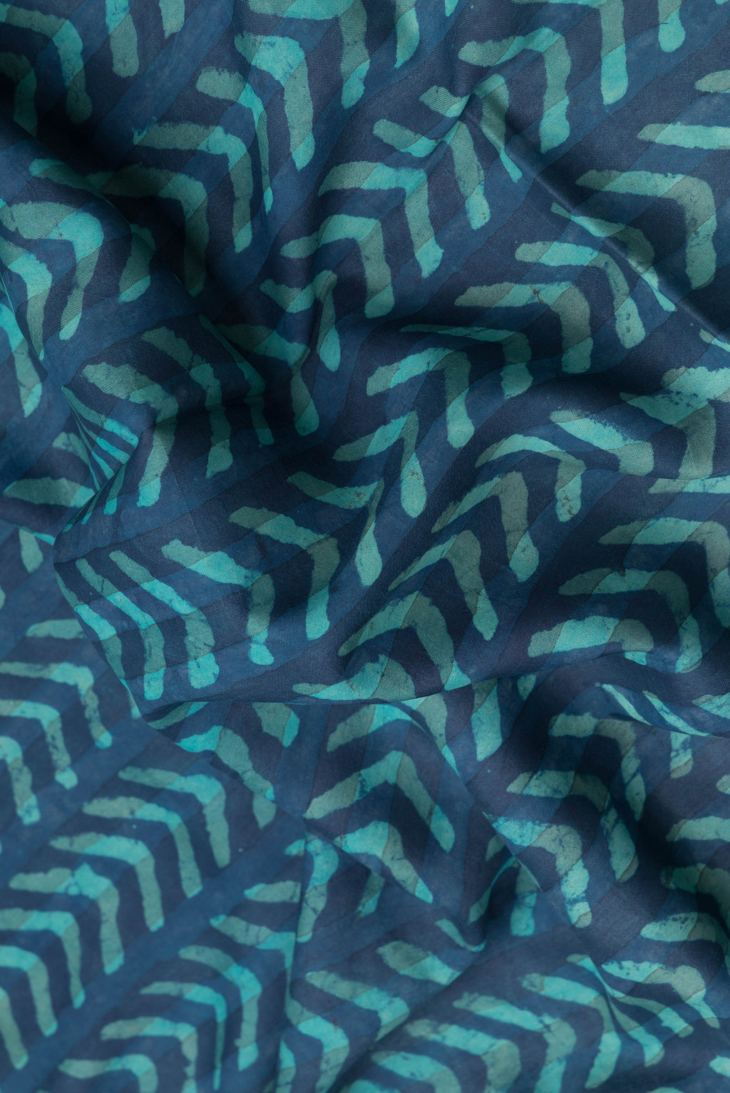 Close up of Peacock Blue Dual Tone Tussar Silk Saree with Printed design on the body and Zari Border.  displaying folds