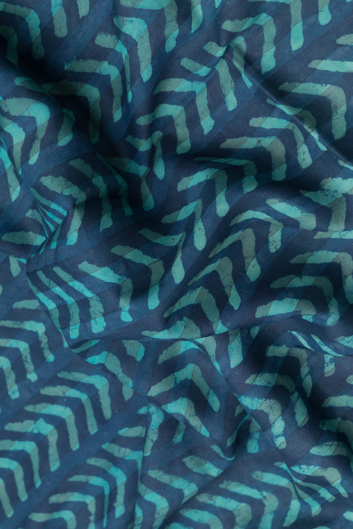 Close up of Peacock Blue Dual Tone Tussar Silk Saree with Printed design on the body and Zari Border.  displaying folds