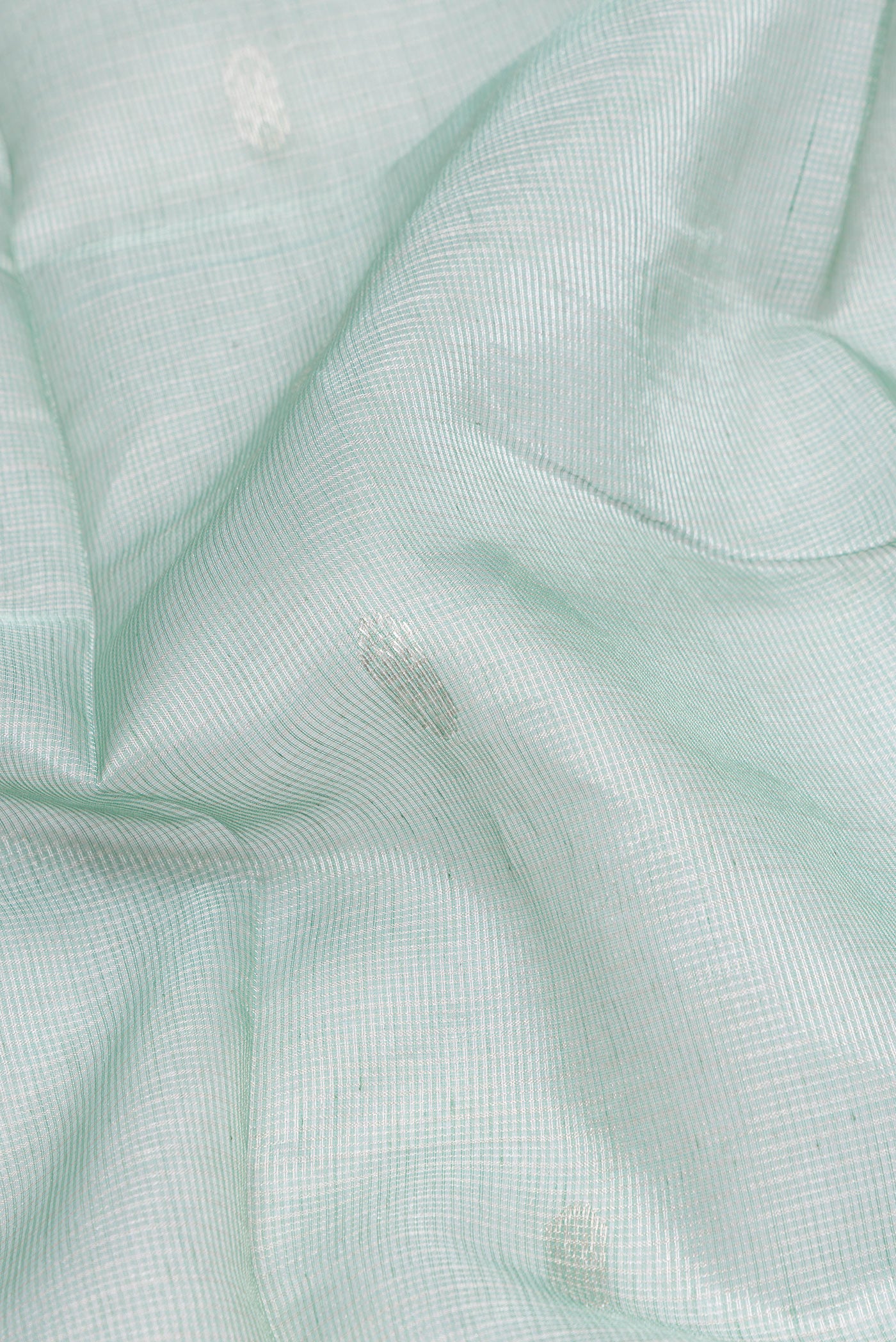 Close up of Sea Green Dual Tone Maheshwari Tissue Silk Cotton Saree with Checked design on the body and Zari Border.  displaying folds