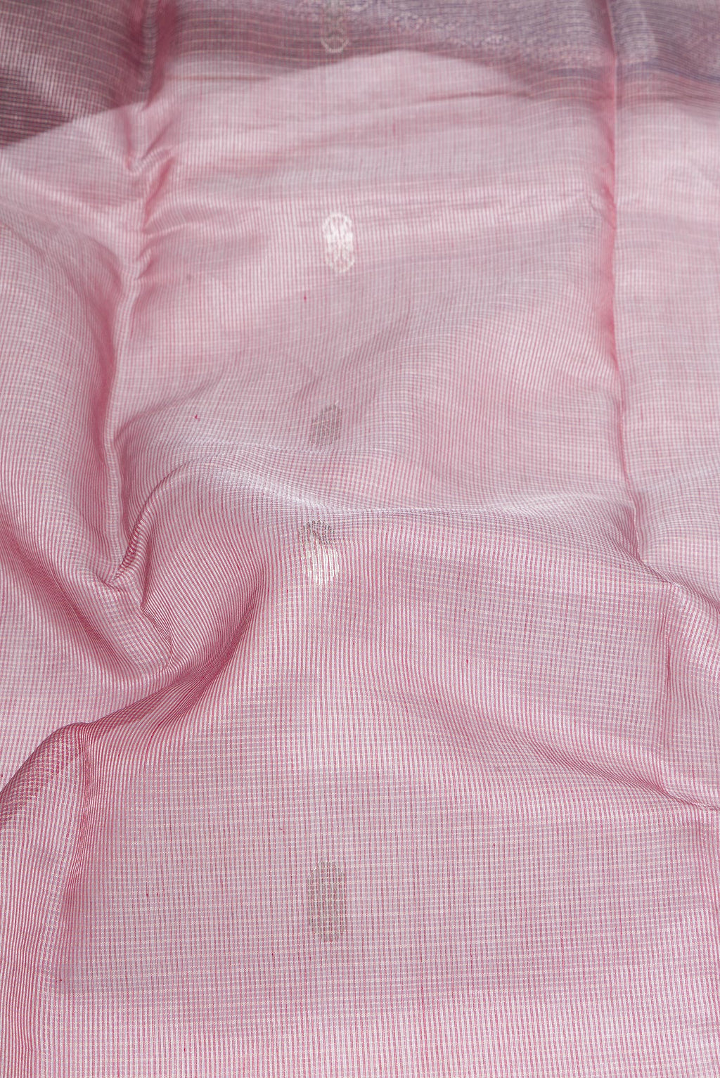 Close up of Rose Gold Maheshwari Tissue Silk Cotton Saree with Zari Butta on the body and Zari Border.  displaying folds