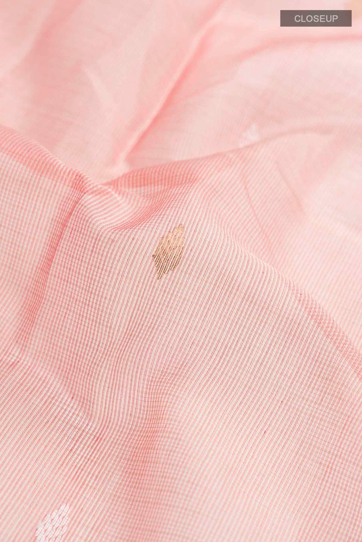 Close up of Coral Maheshwari Silk Cotton Saree with Zari Butta on the body and Zari Border displaying folds