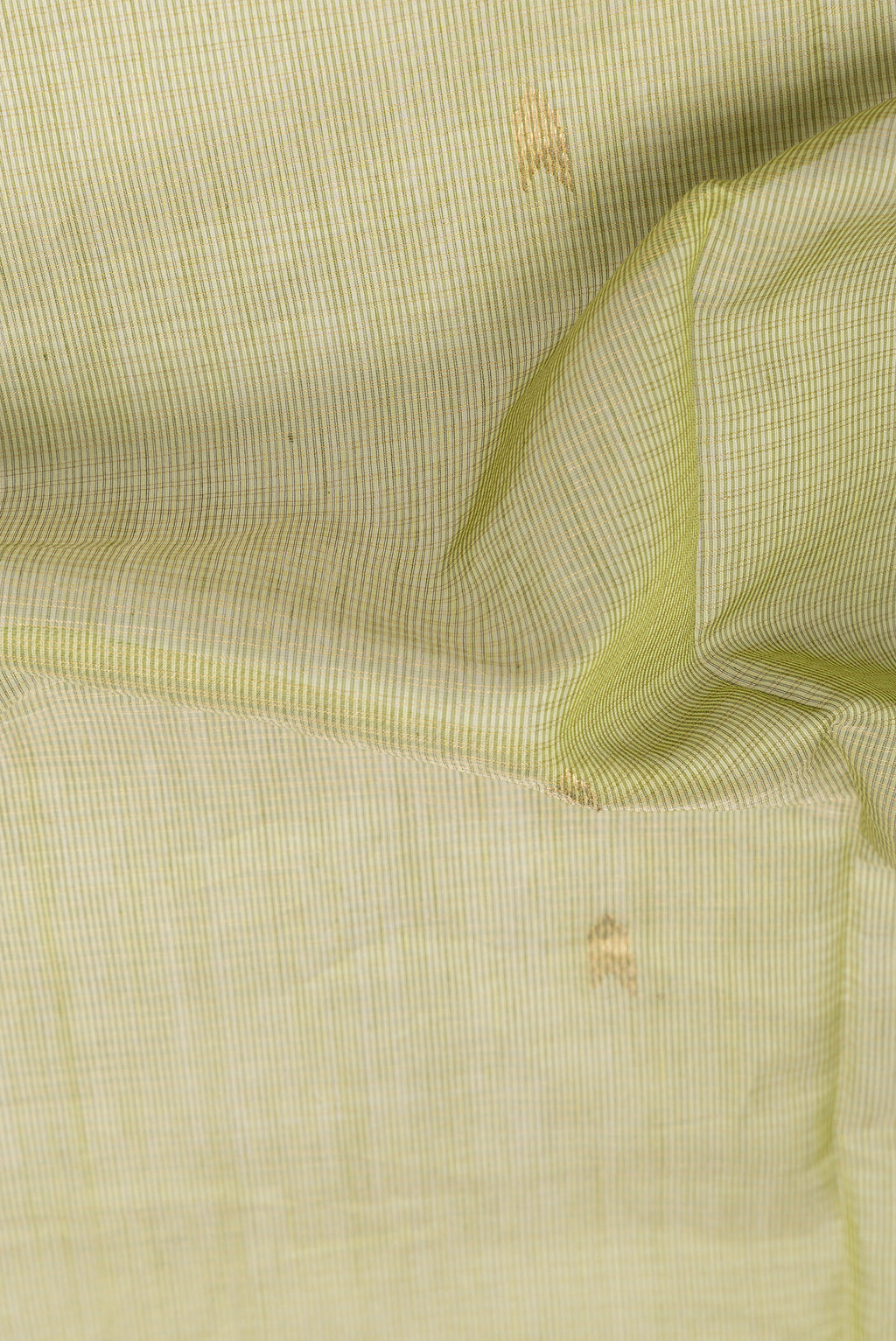 Close up of Mehandi Green Maheshwari Silk Cotton Saree with Zari Butta on the body and Zari Border.  displaying folds