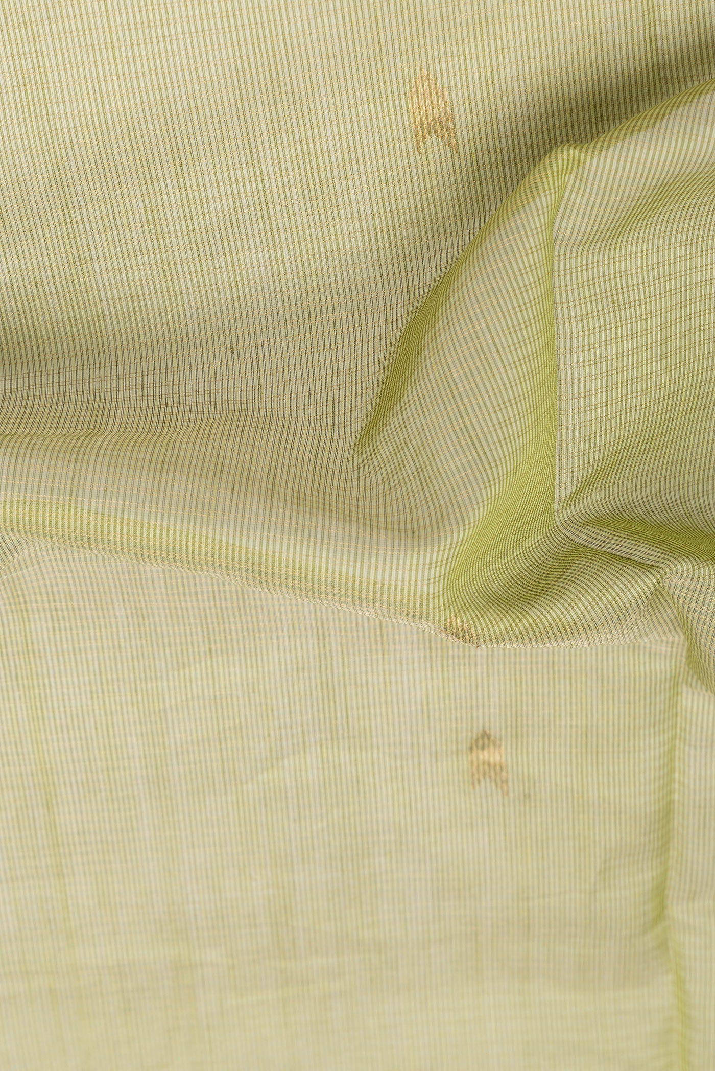 Close up of Mehandi Green Maheshwari Silk Cotton Saree with Zari Butta on the body and Zari Border.  displaying folds