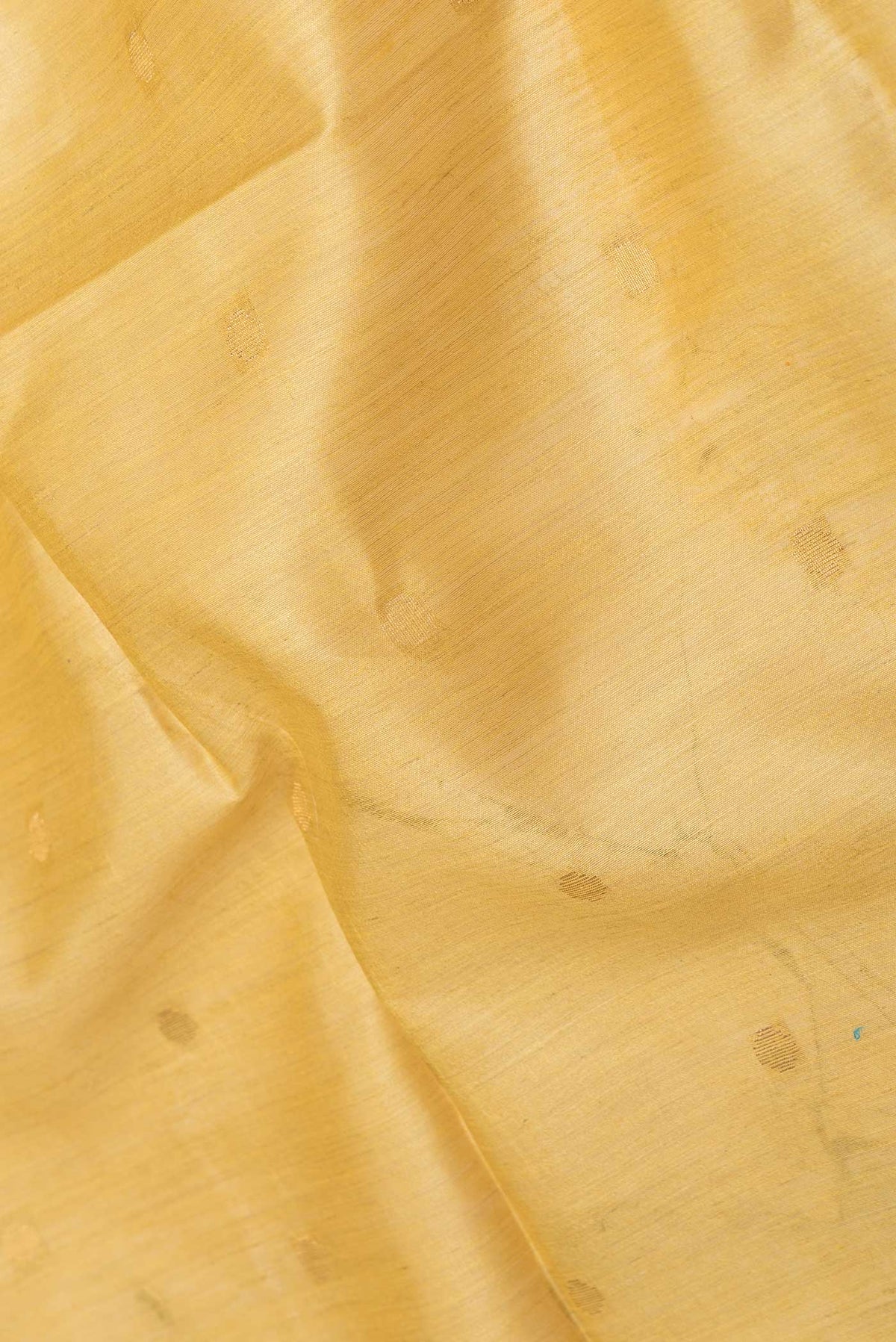 Close up of Mustard Dual Tone Tussar Saree with Zari Butta on the body and Zari Border displaying folds