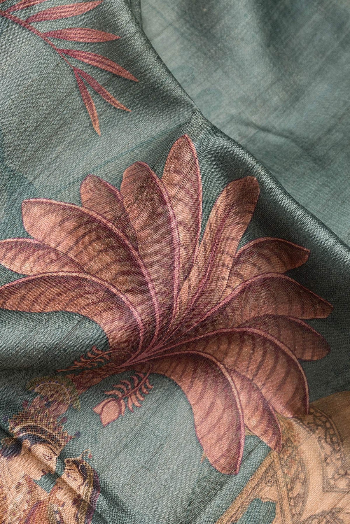 Close up of Green Dual Tone Tussar Silk Saree with Printed design on the body and Fancy Border.  displaying folds